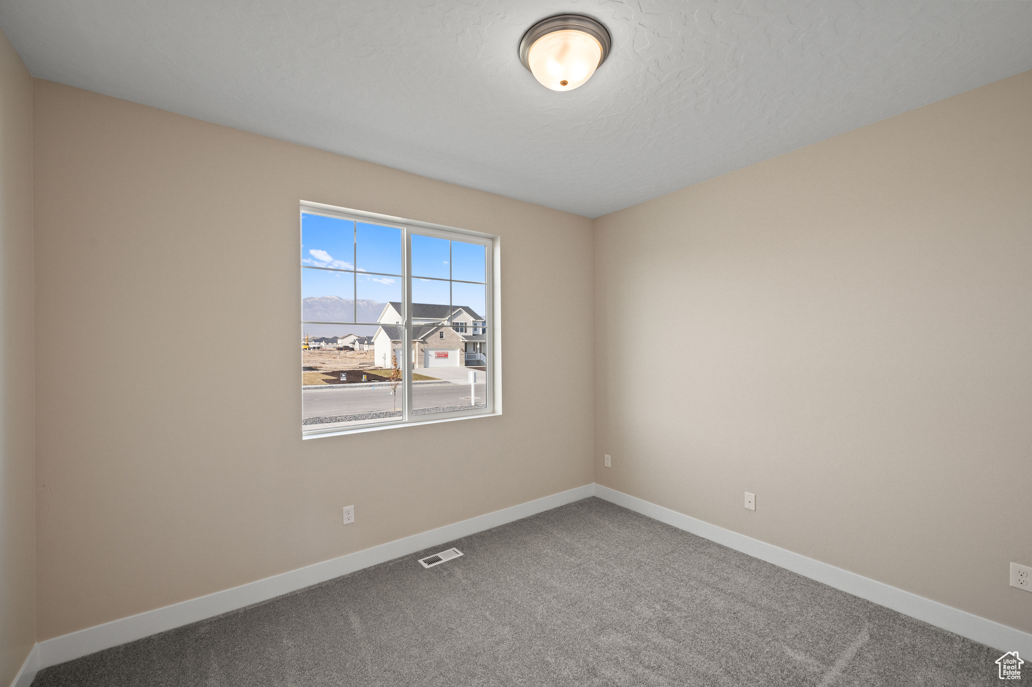 Unfurnished room featuring carpet floors and a textured ceiling