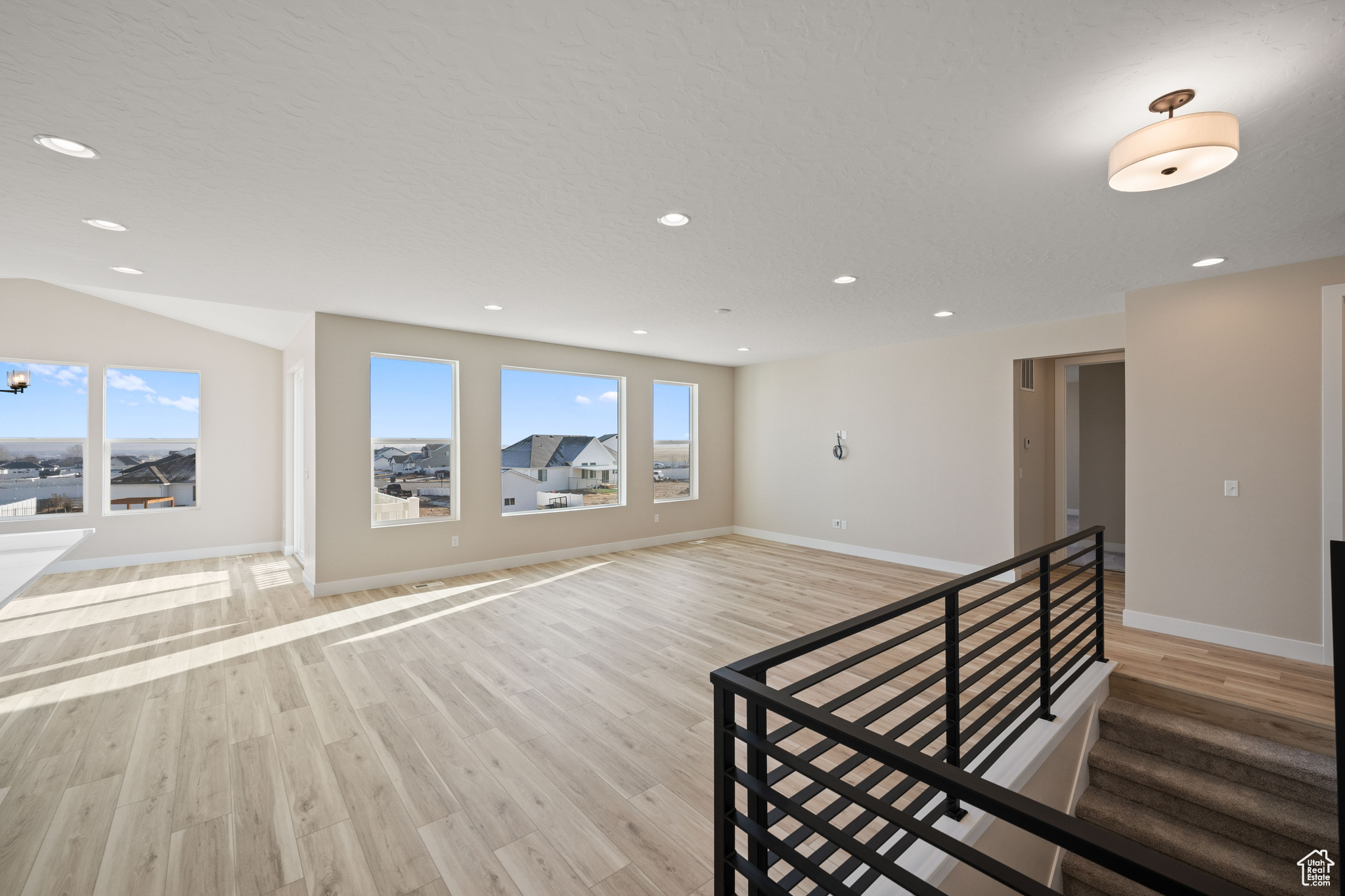 Empty room featuring a wealth of natural light and light wood-type flooring