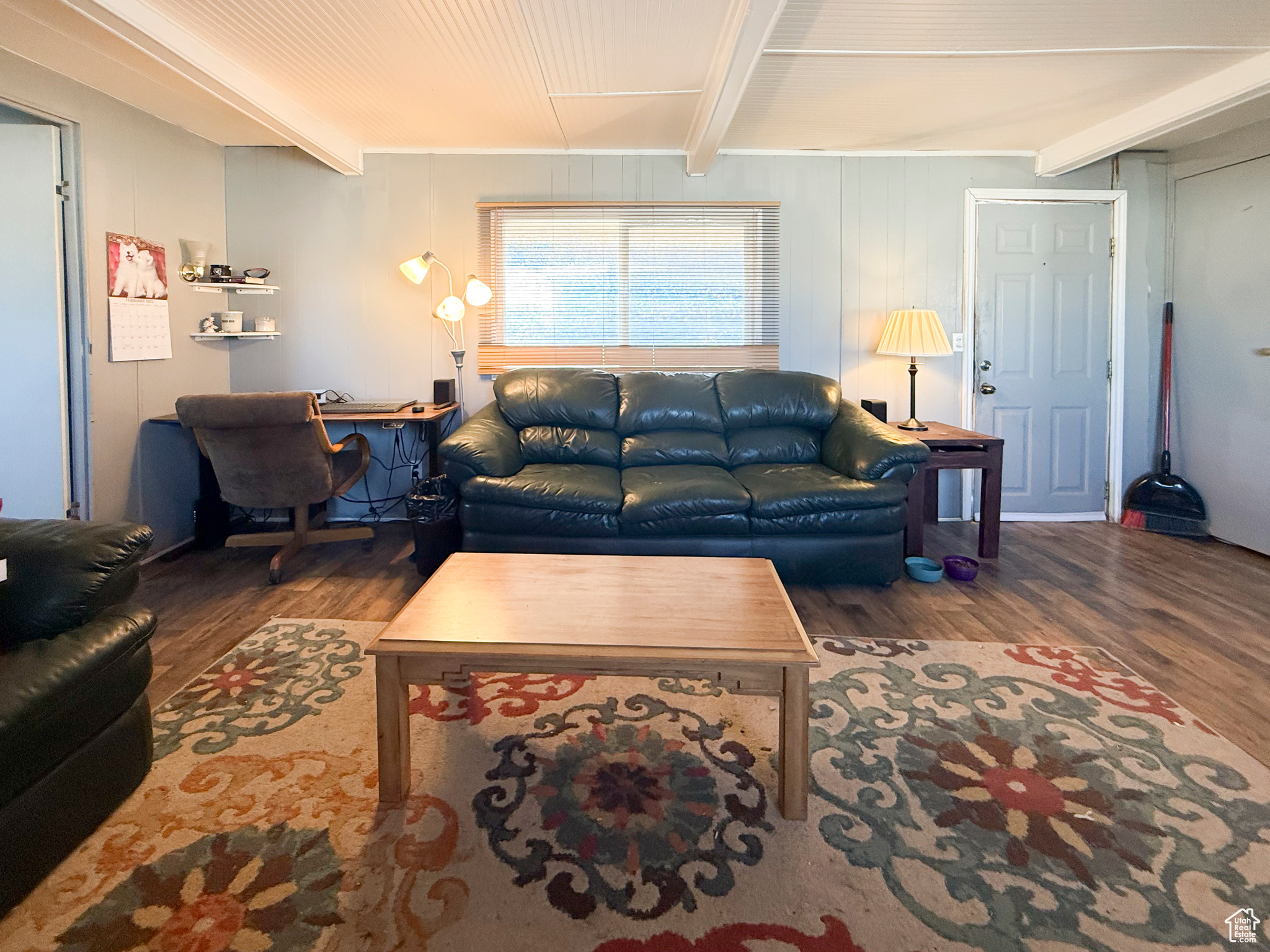 Living room featuring beamed ceiling and dark hardwood / wood-style flooring