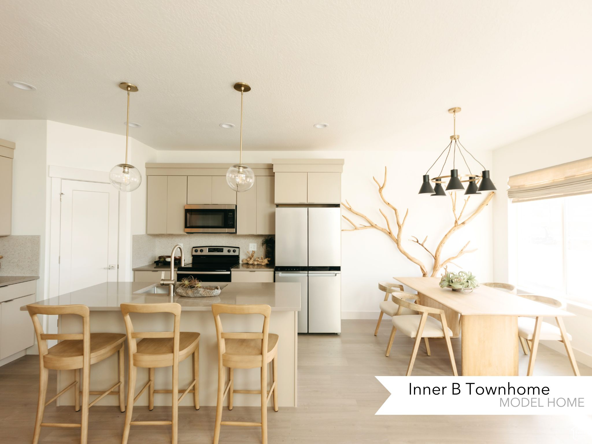 Kitchen with sink, backsplash, stainless steel appliances, a center island with sink, and light wood-type flooring