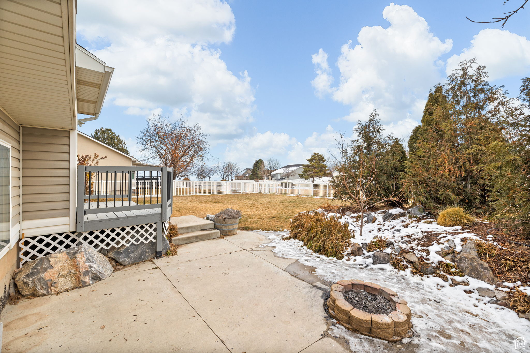 View of patio featuring a wooden deck and a fire pit