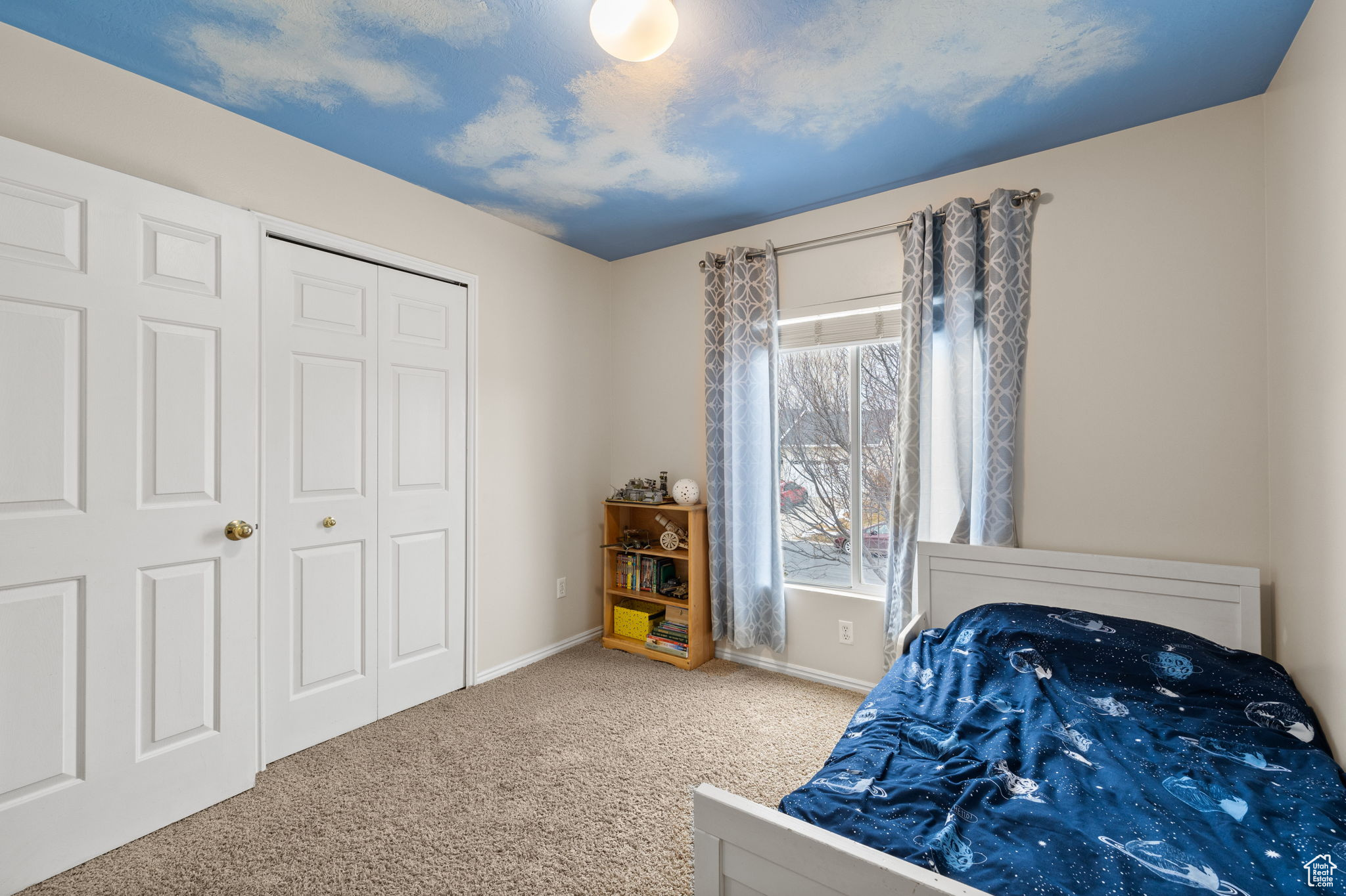 Carpeted bedroom with a closet