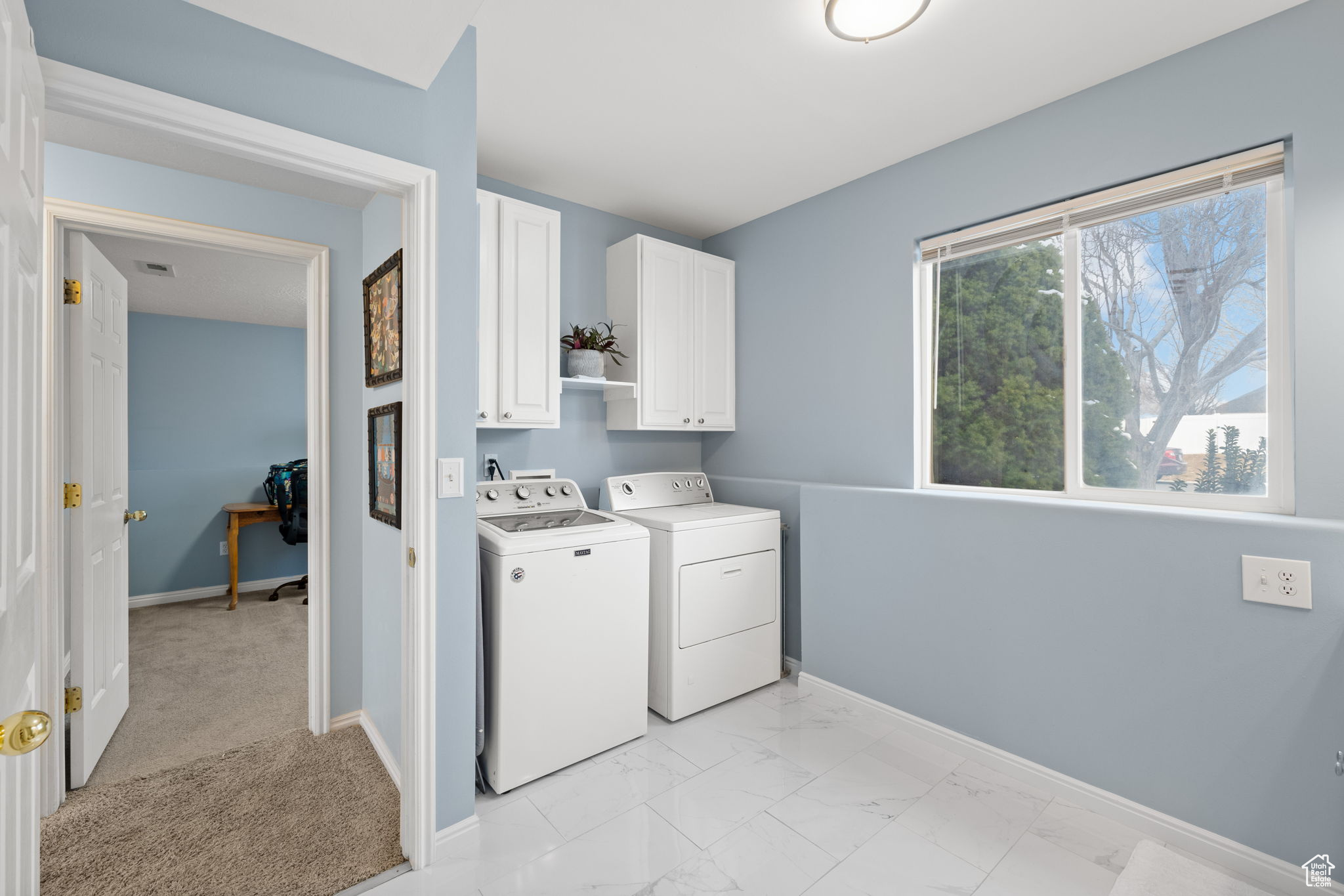 Washroom featuring cabinets and washer and dryer