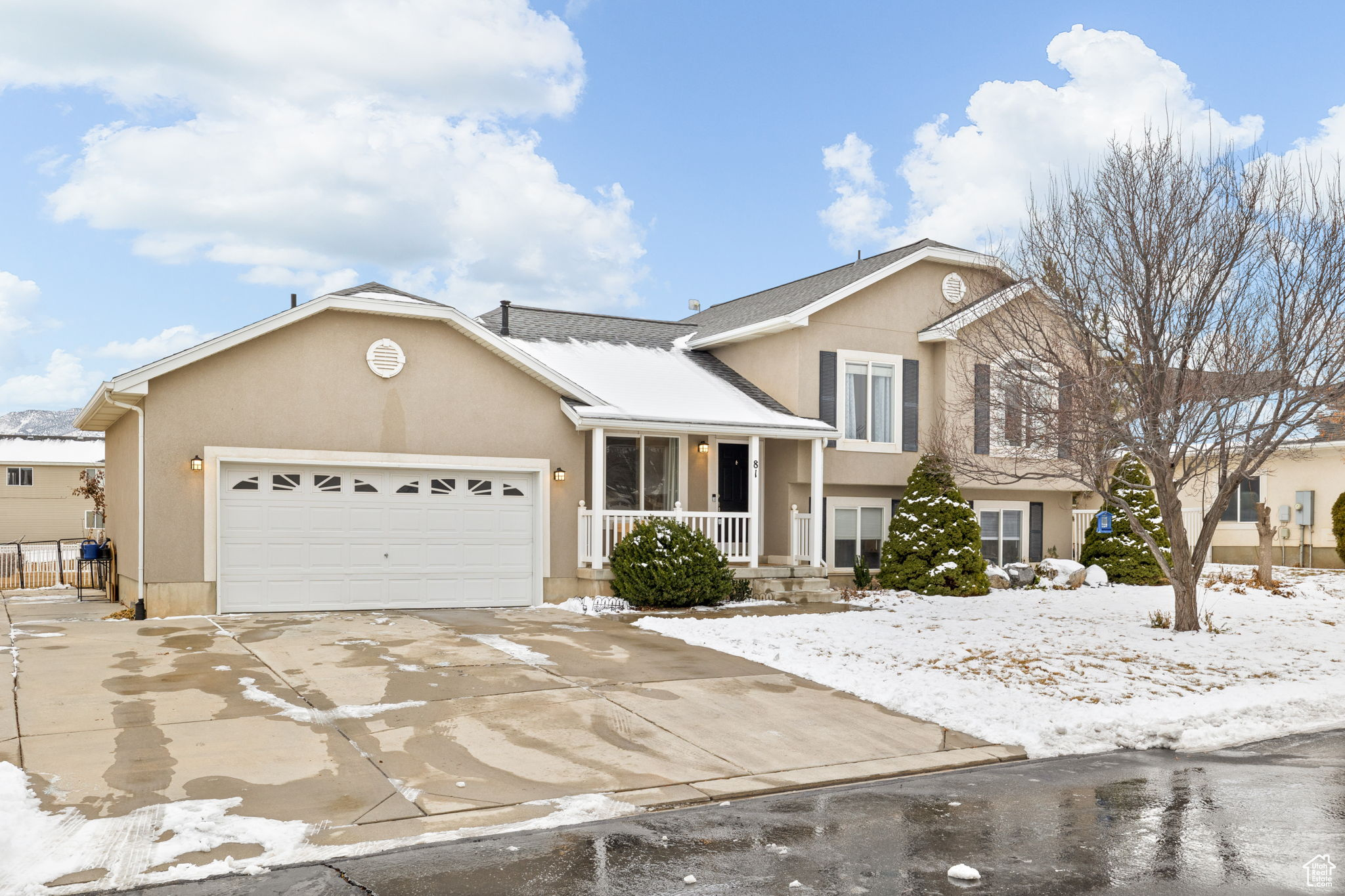 Tri-level home featuring a garage and a porch