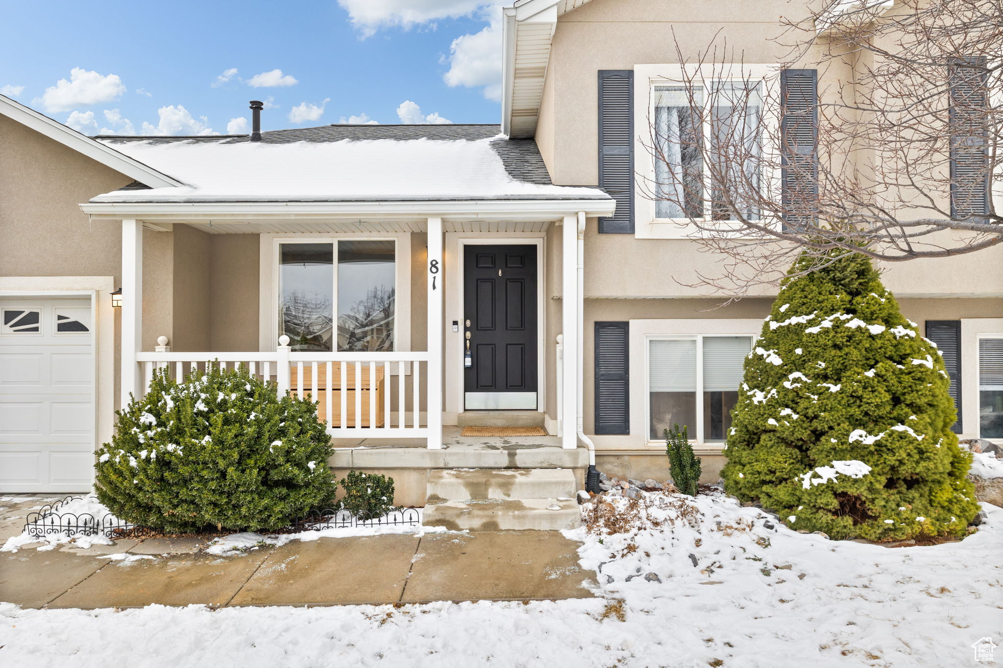 Snow covered property entrance with a porch