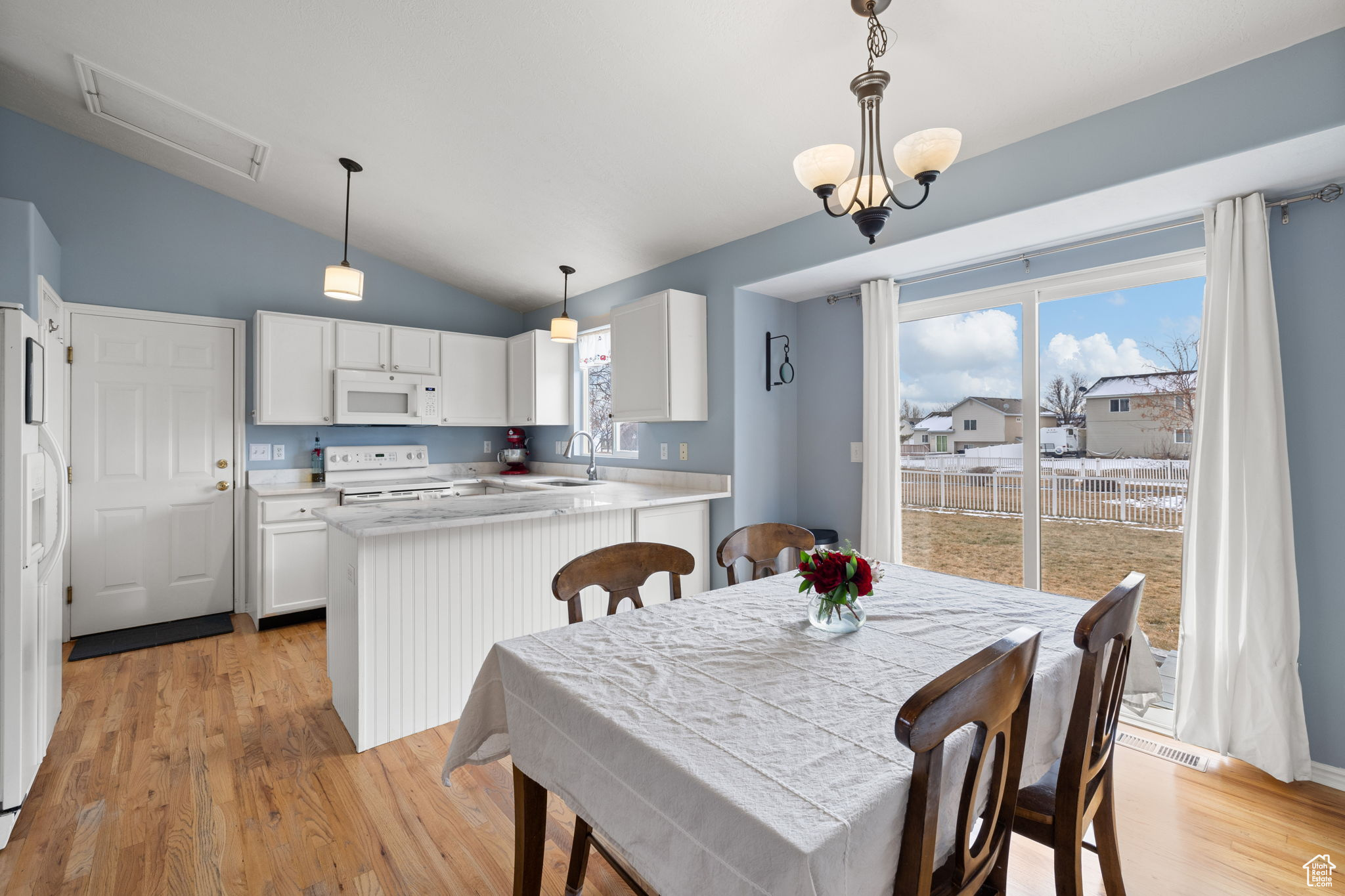 Dining space featuring lofted ceiling, sink, a wealth of natural light, and light wood-type flooring