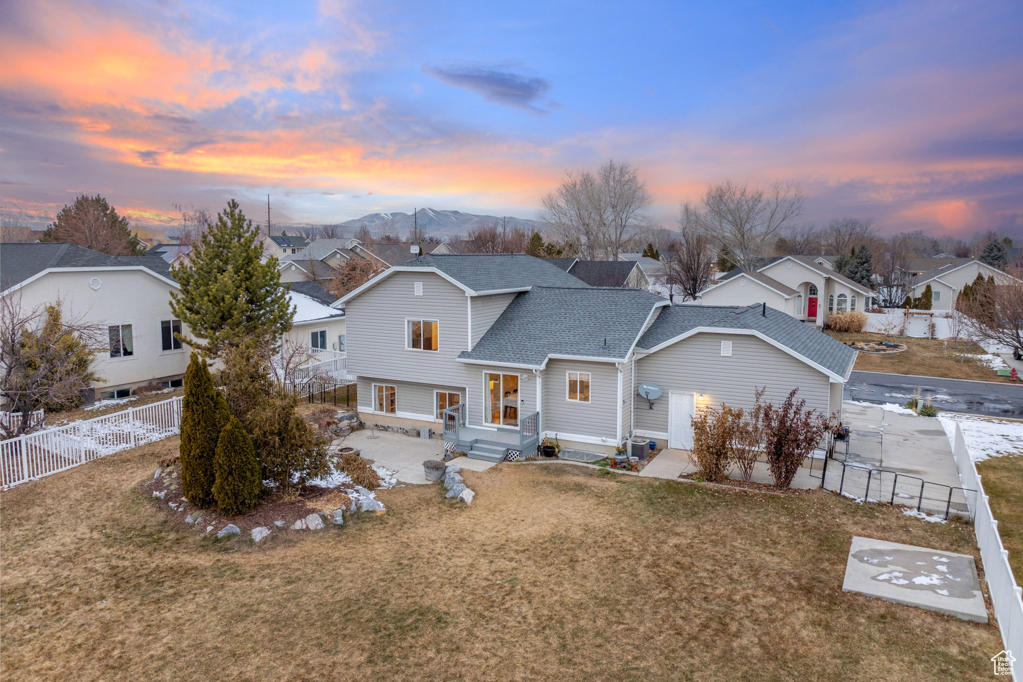 View of front of home with a mountain view, a patio area, and a lawn