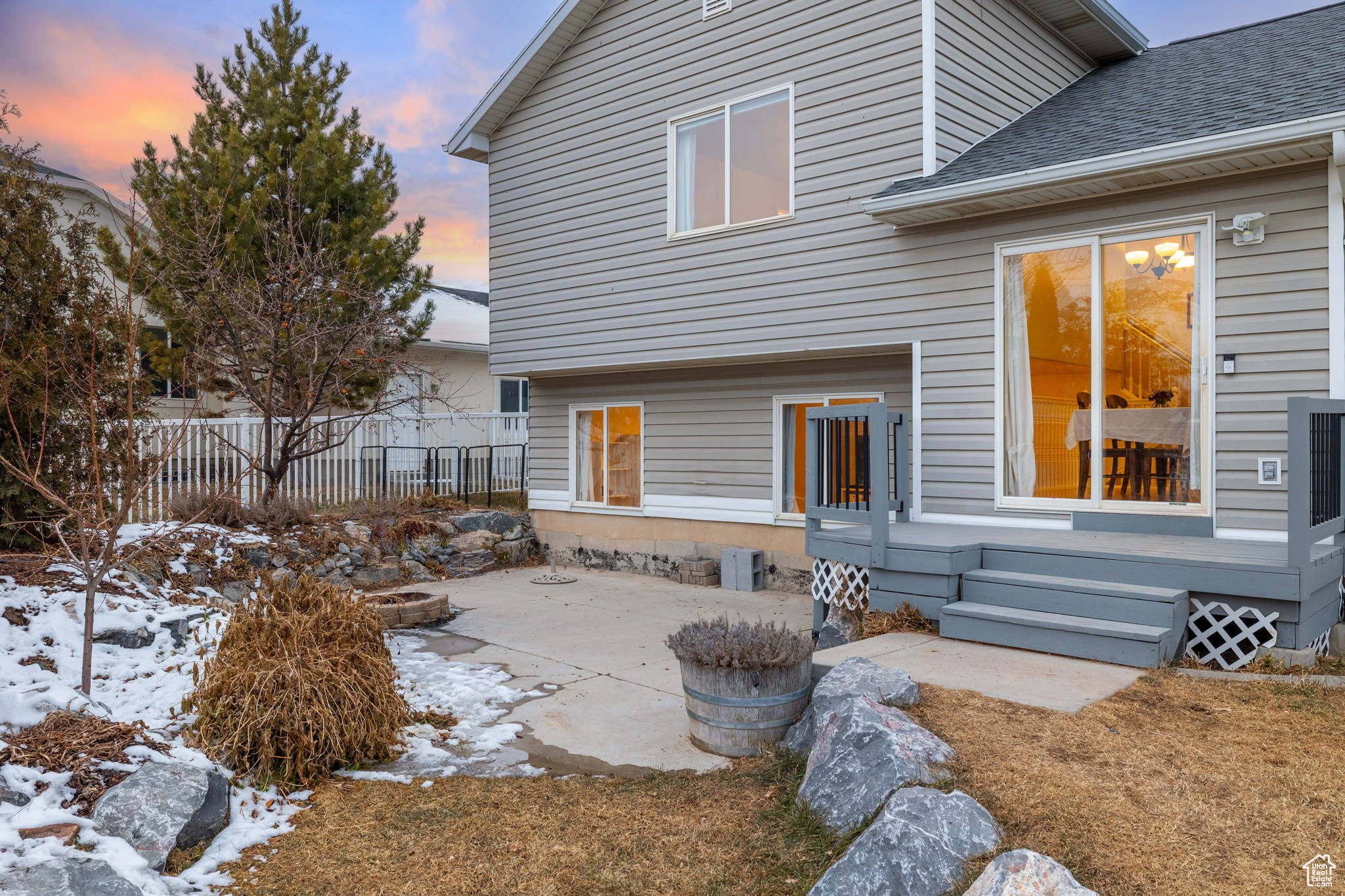 Snow covered back of property featuring a patio area