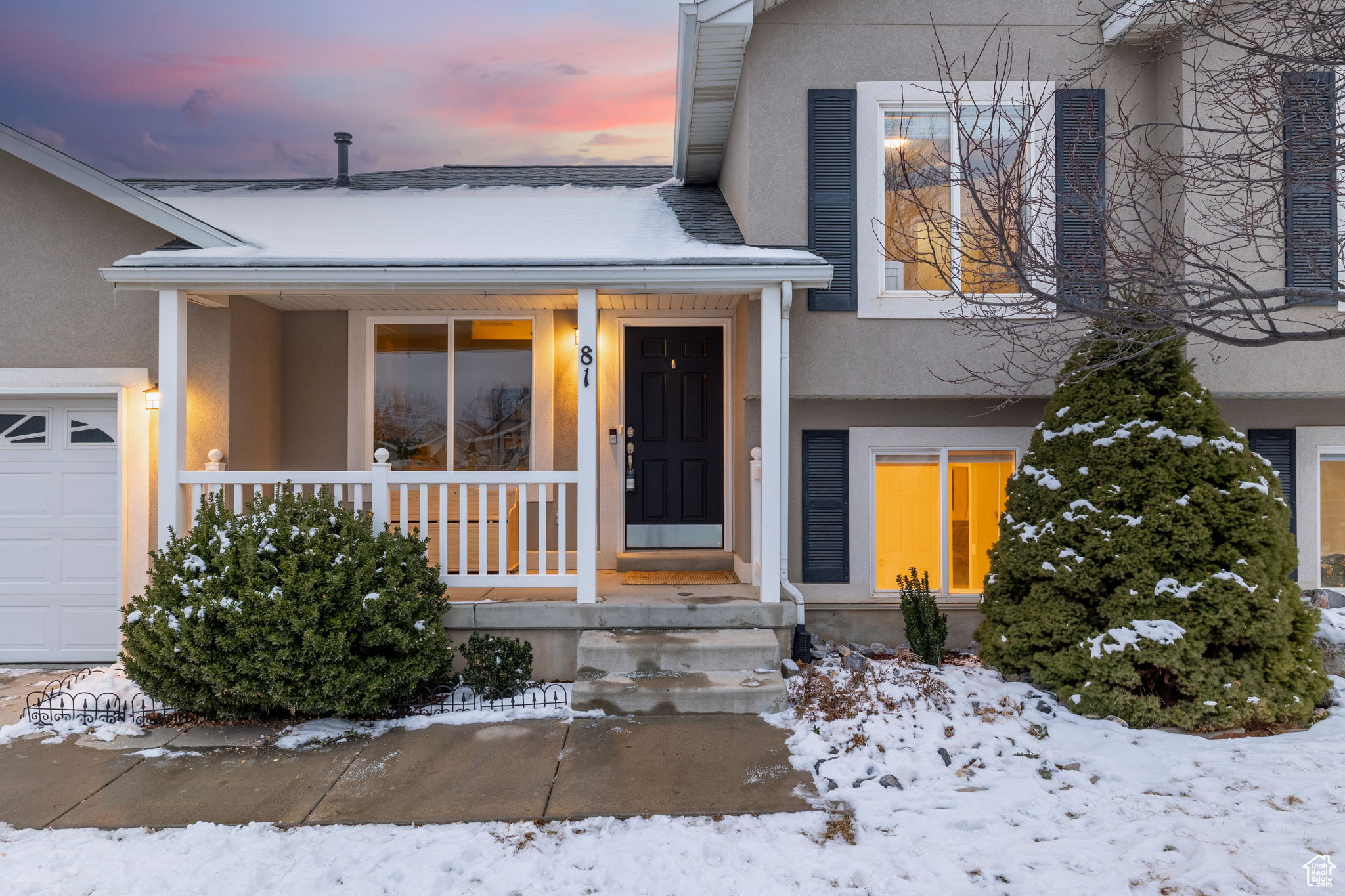 Snow covered property entrance with a porch