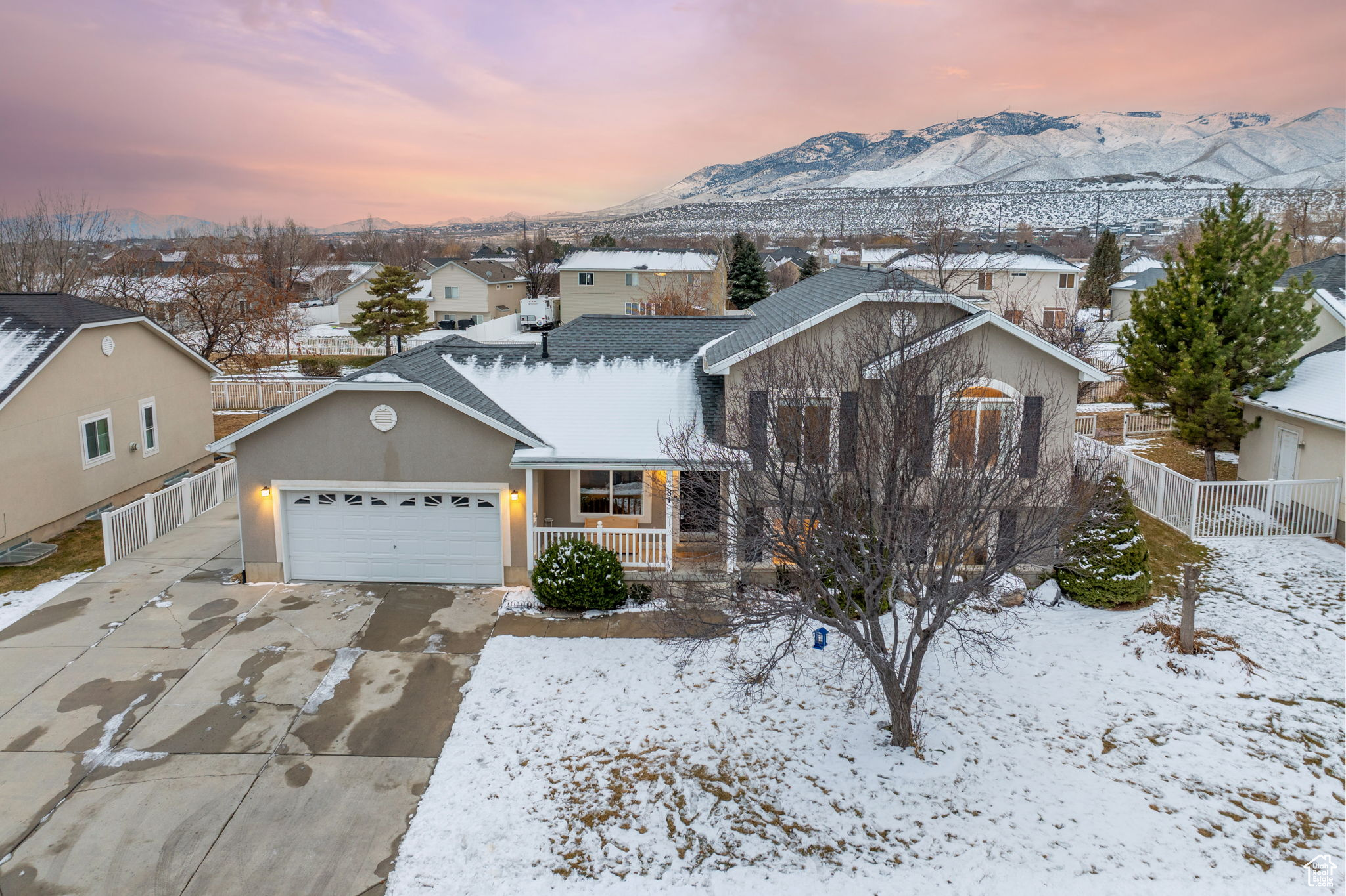 View of front of house with a mountain view, a garage, and covered porch