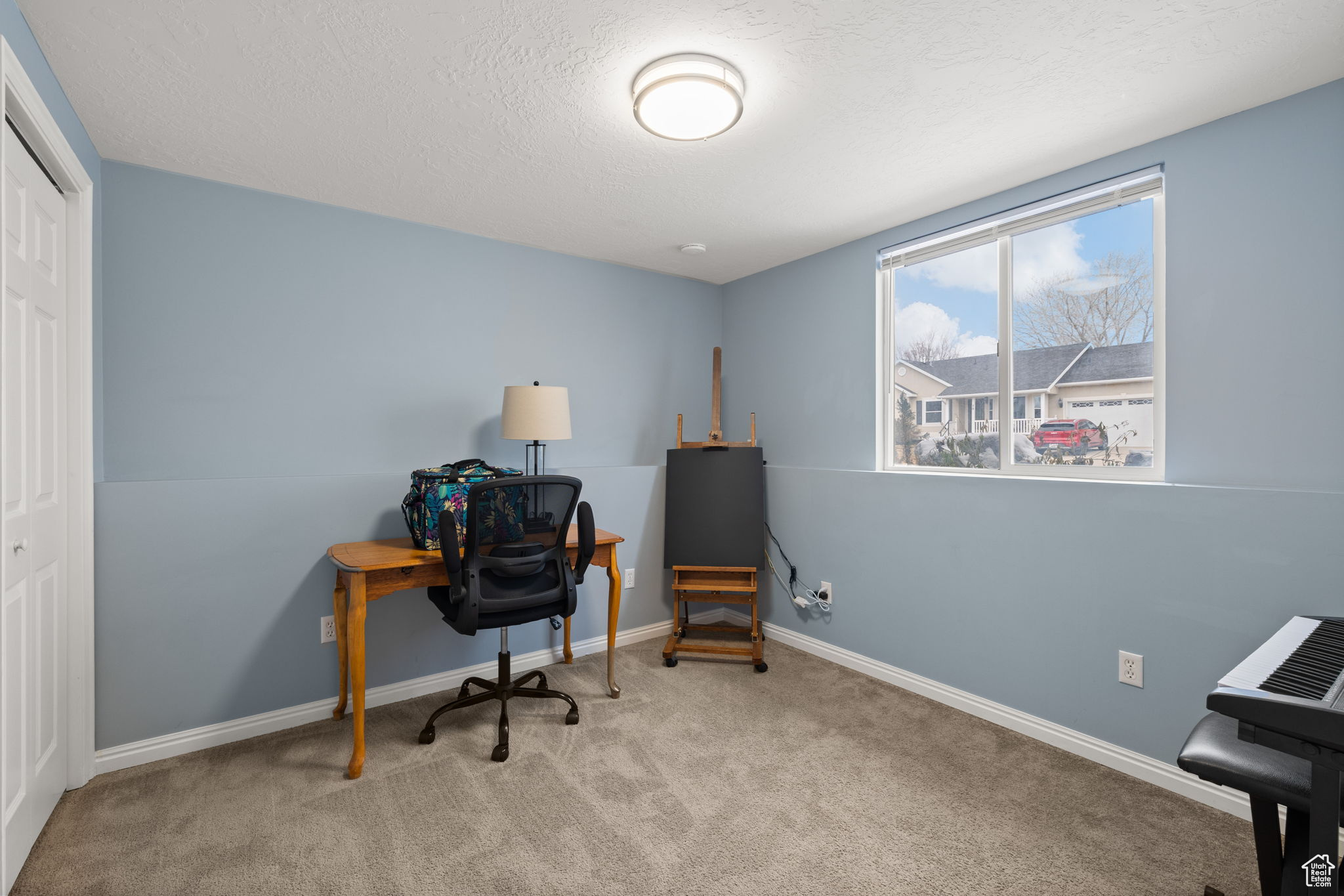 Office area with light carpet and a textured ceiling