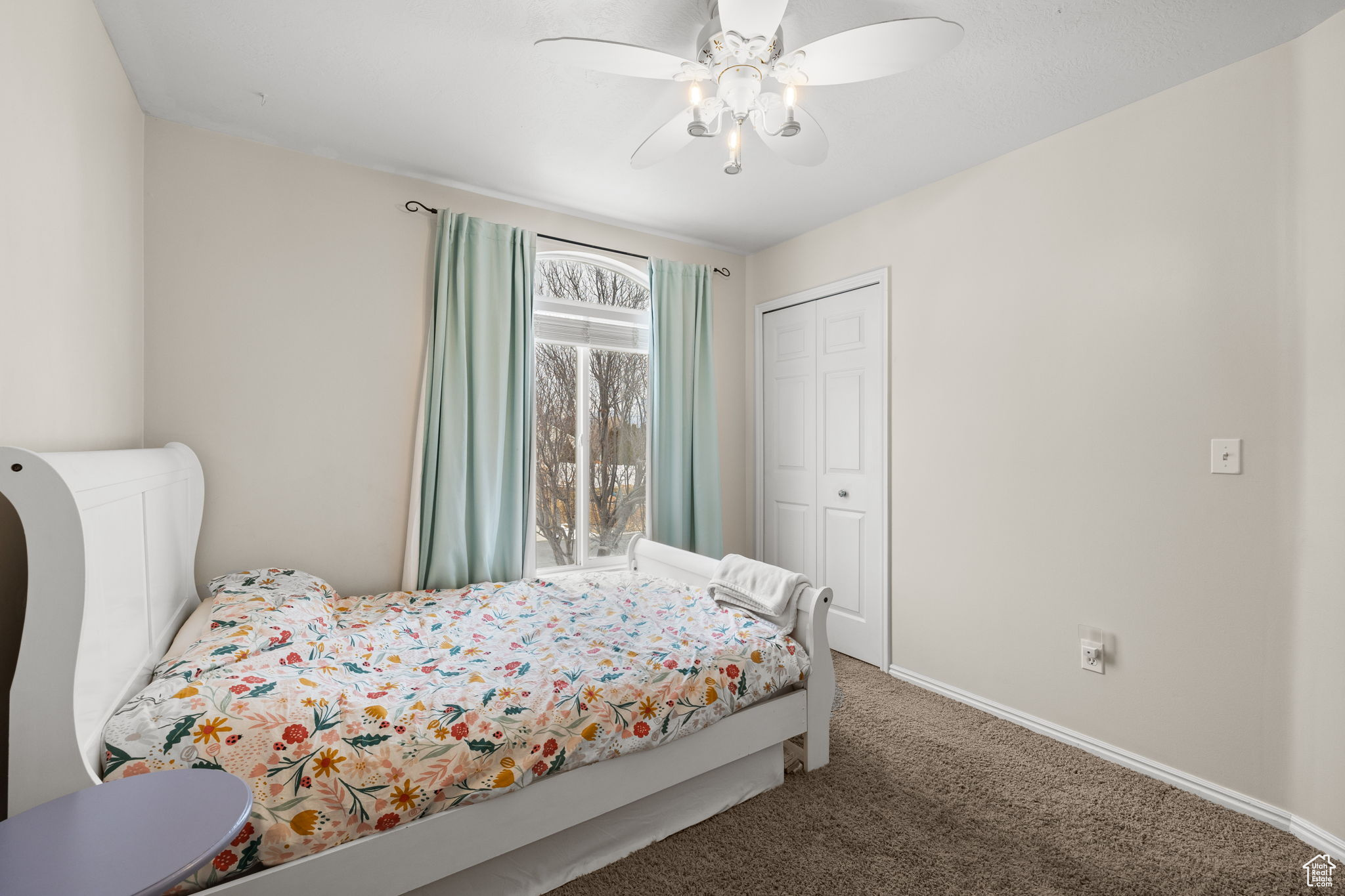 Bedroom with ceiling fan, a closet, and carpet