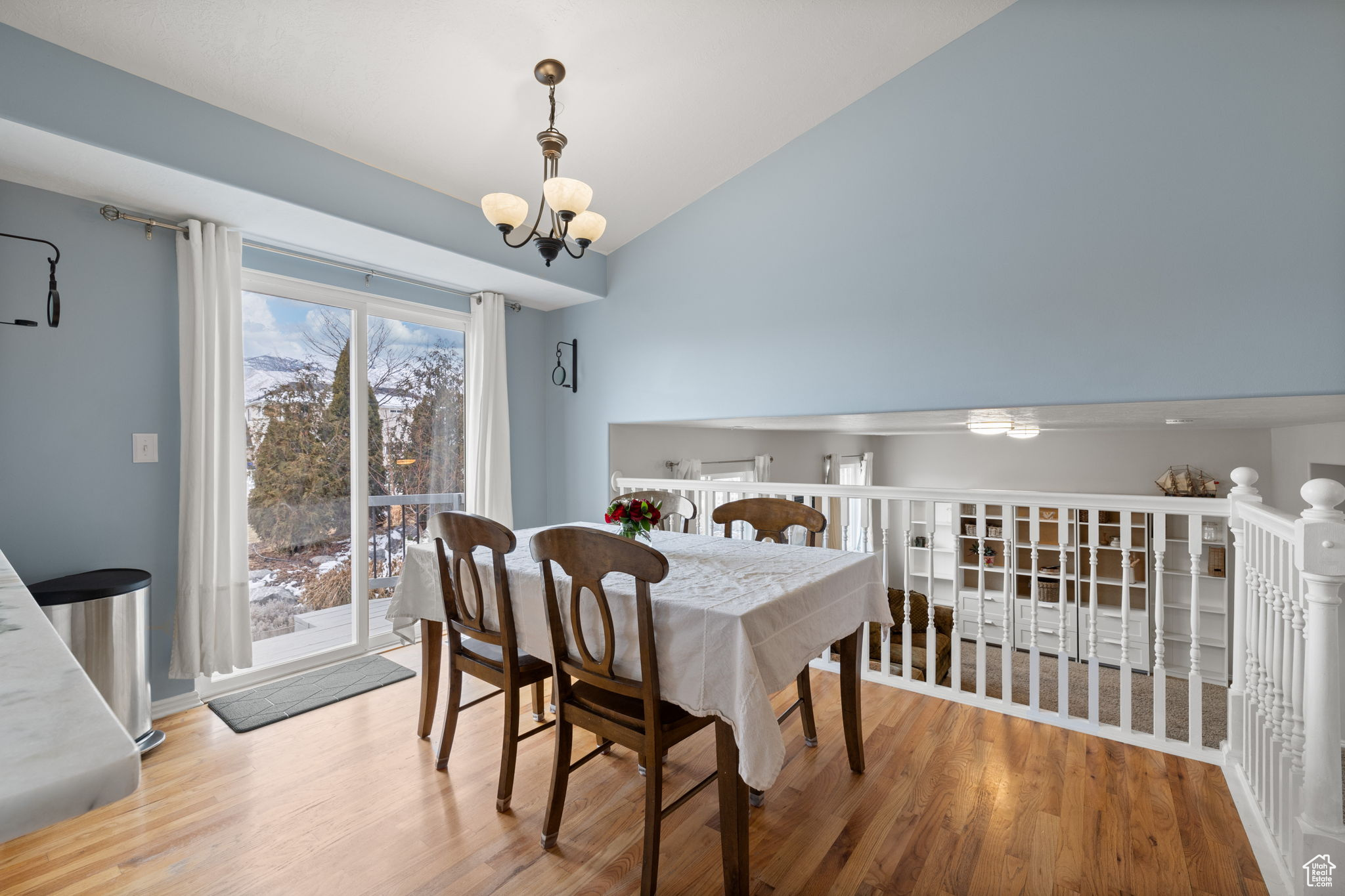 Dining area with lofted ceiling, a chandelier, and hardwood / wood-style floors