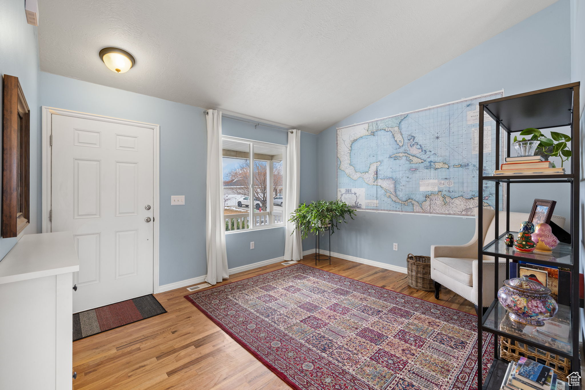 Foyer with hardwood / wood-style flooring and vaulted ceiling