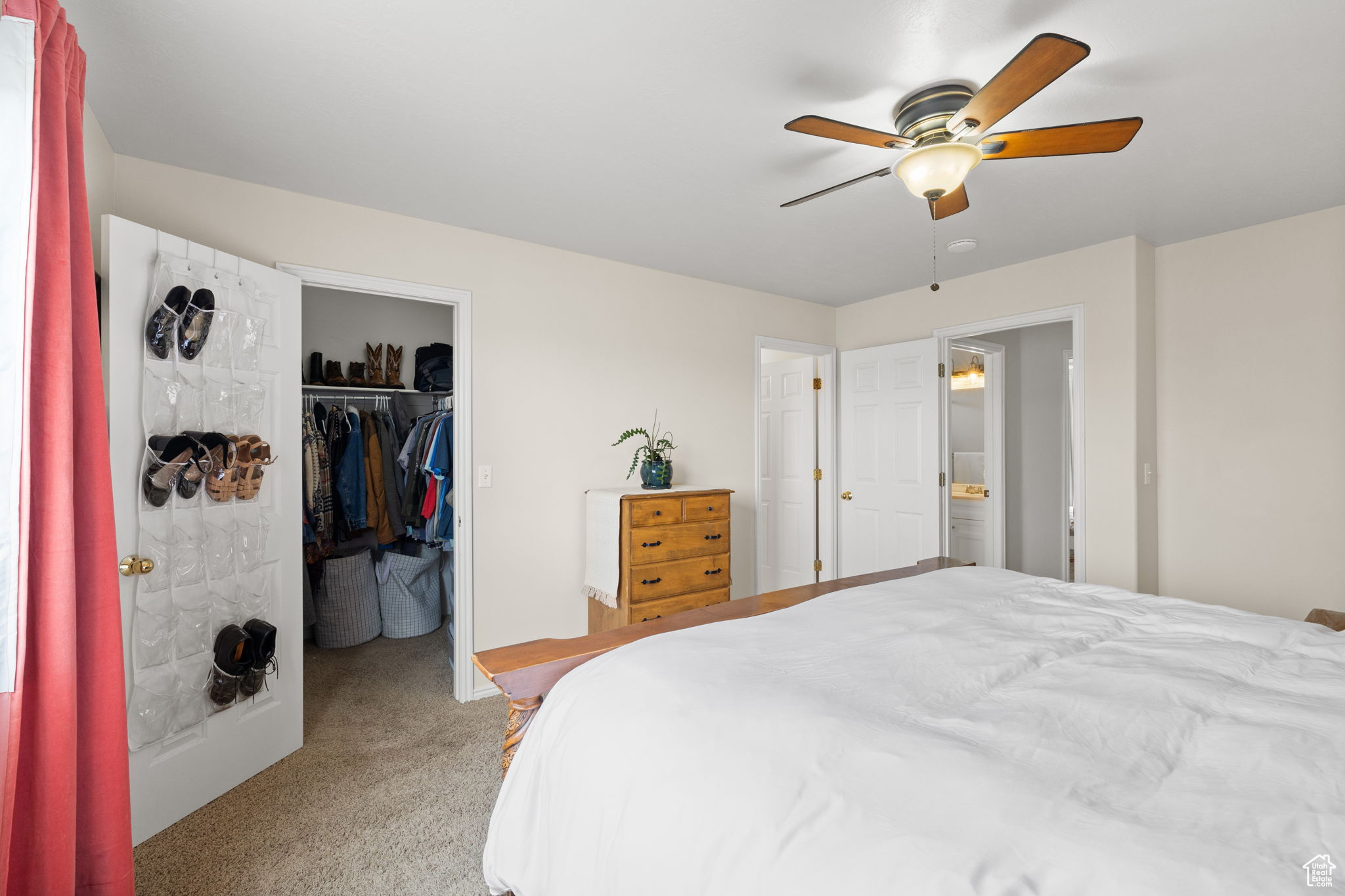 Carpeted bedroom featuring a walk in closet, ceiling fan, and a closet