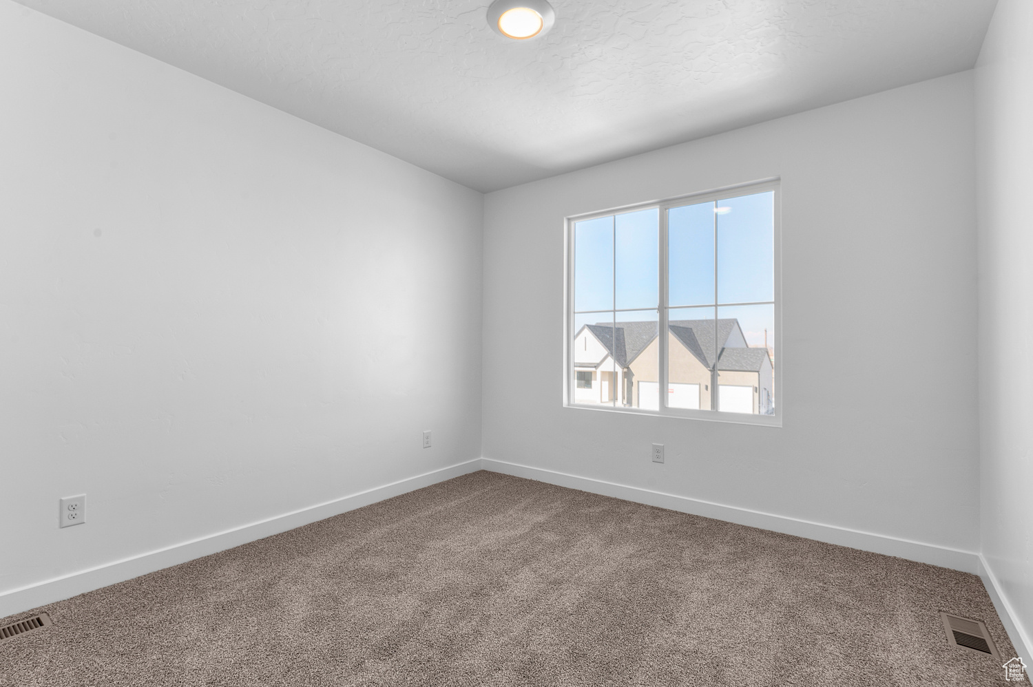 Carpeted empty room featuring a textured ceiling