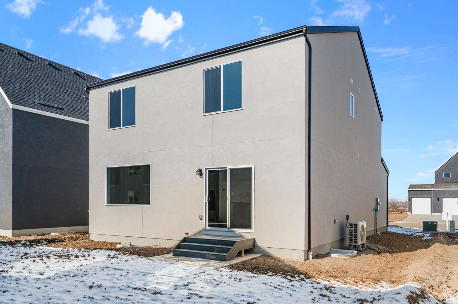 Snow covered property featuring ac unit