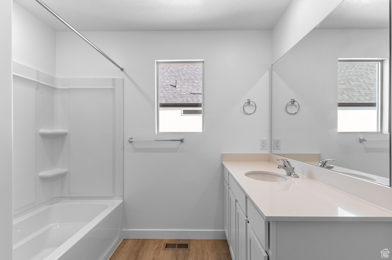 Bathroom featuring vanity, hardwood / wood-style floors, and  shower combination