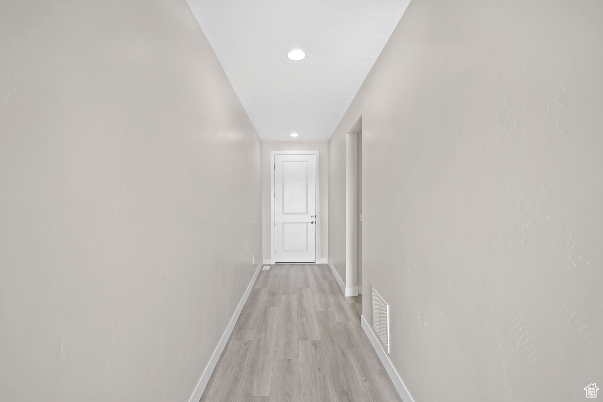 Hallway with light hardwood / wood-style floors