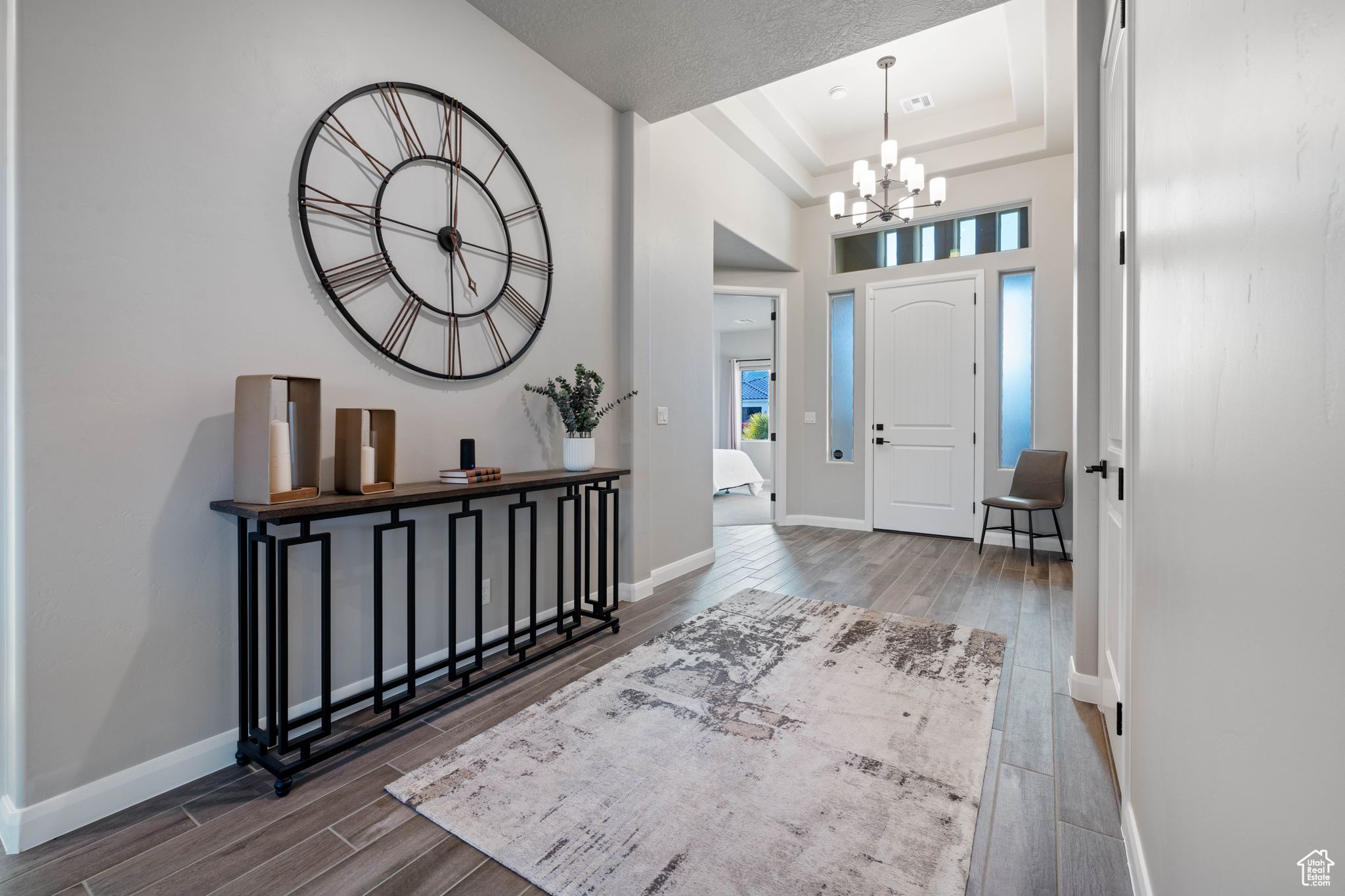 Entryway with a towering ceiling, a raised ceiling, and a chandelier