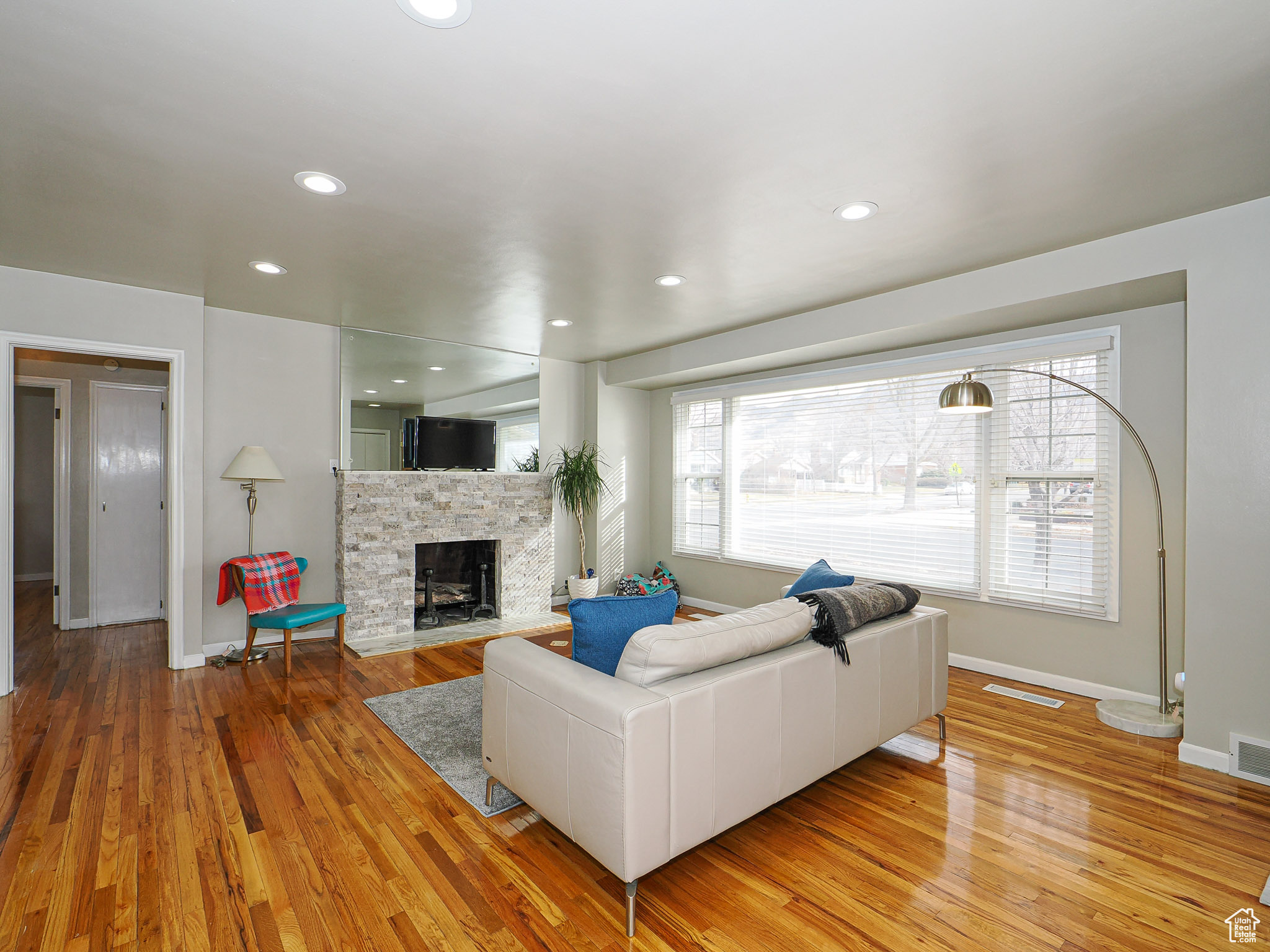 Living room with hardwood / wood-style flooring and a stone fireplace