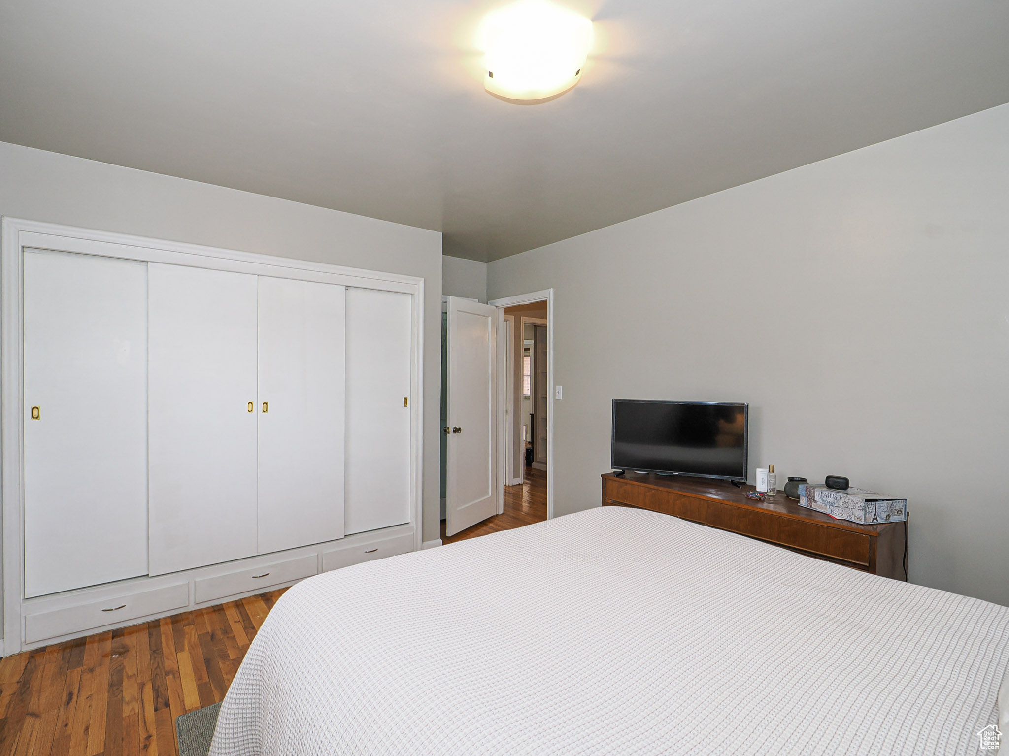 Bedroom with hardwood / wood-style floors and a closet