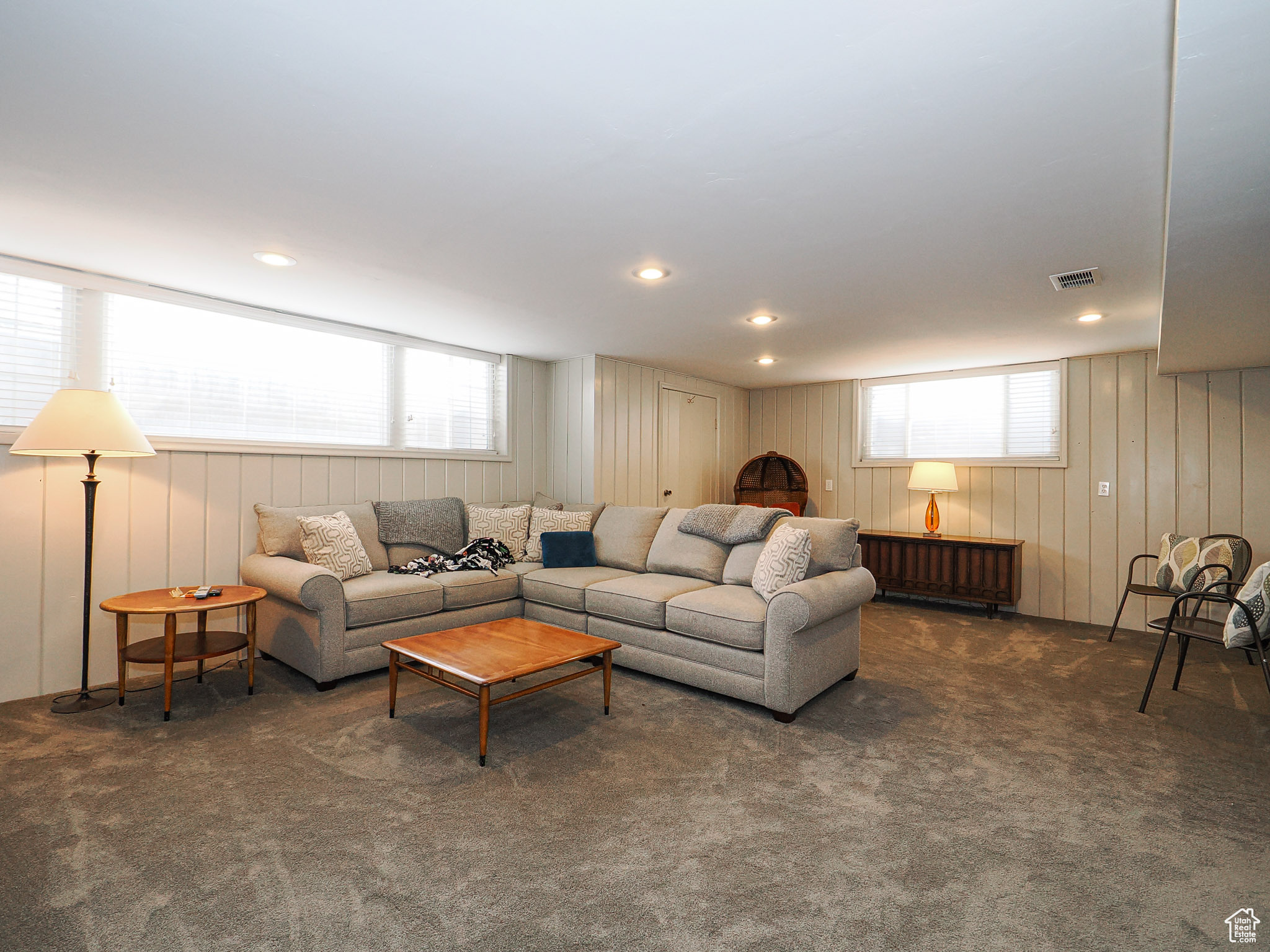 Living room with dark carpet, a wealth of natural light, and radiator heating unit