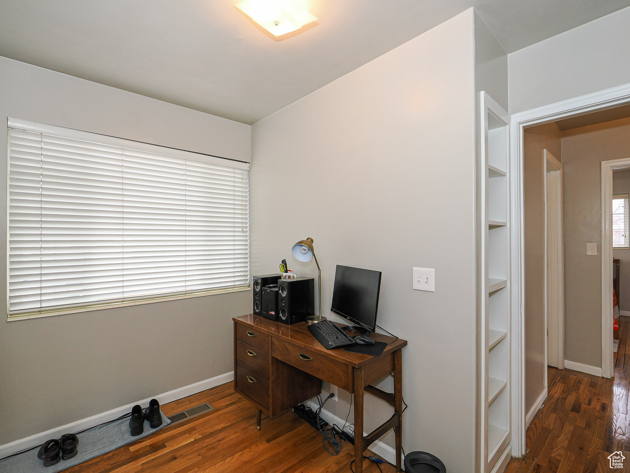 Office space with dark hardwood / wood-style floors