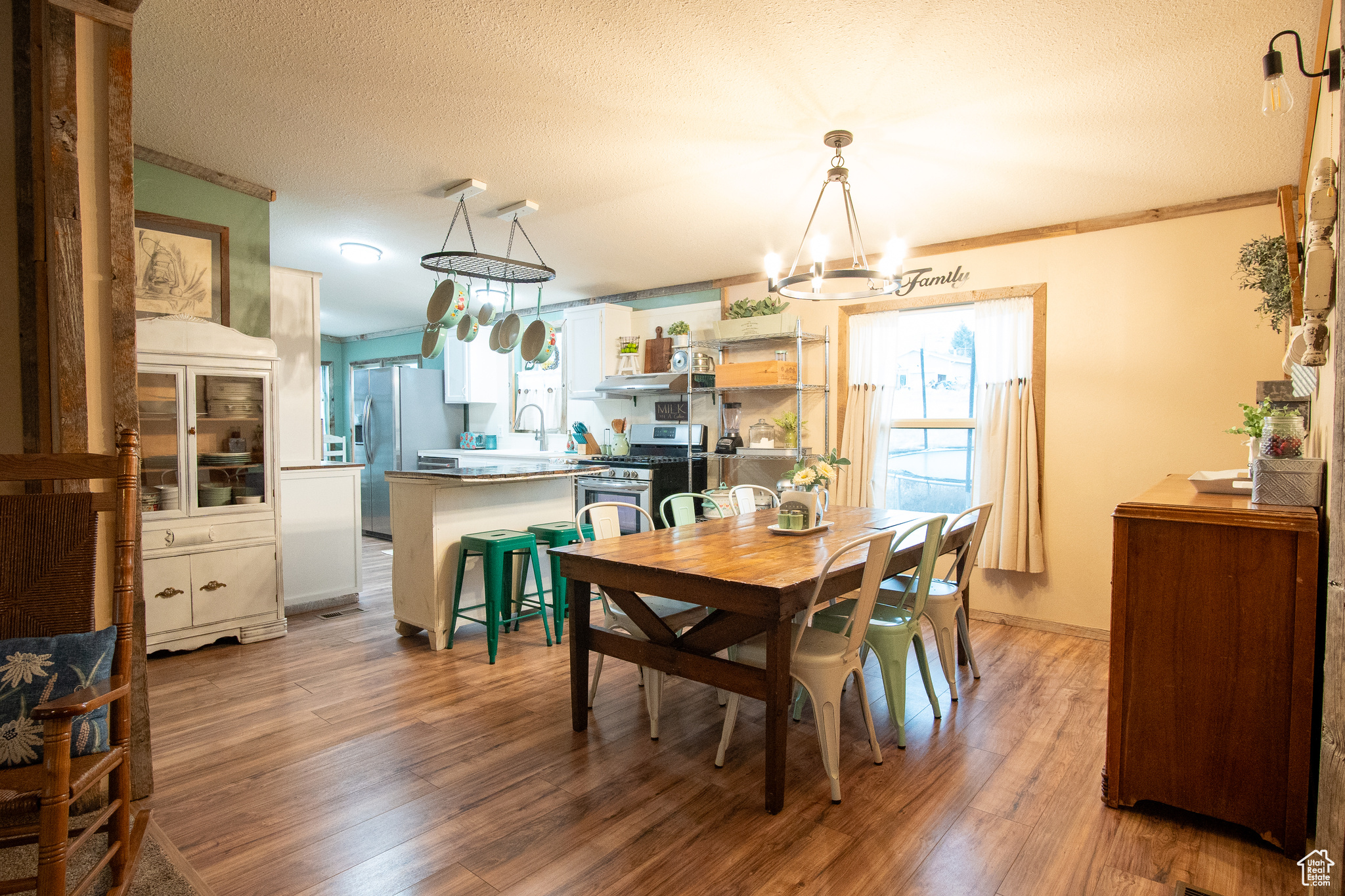 Dining space featuring crown molding, hardwood / wood-style floors, a notable chandelier, and a textured ceiling