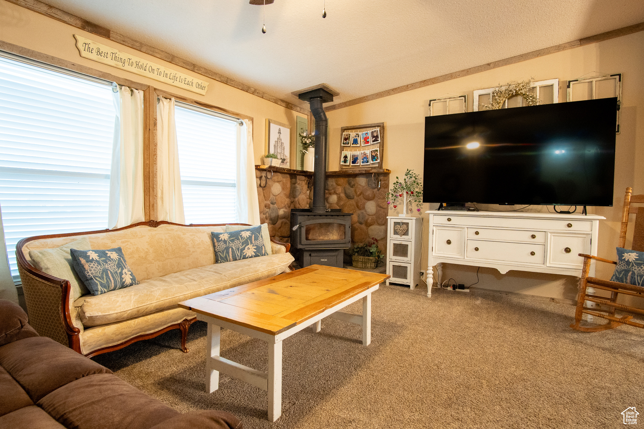 Living room with light carpet and a wood stove