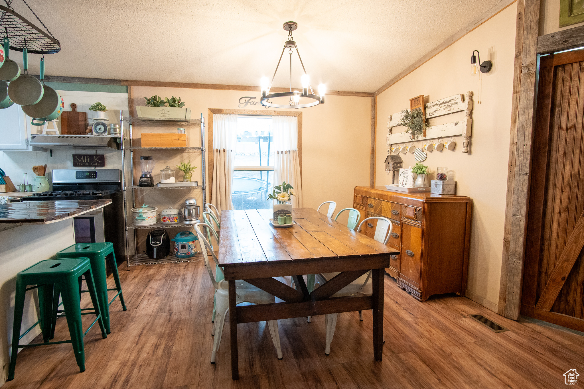 ,j.b room with ornamental molding, a chandelier, a textured ceiling, and light wood-type flooring