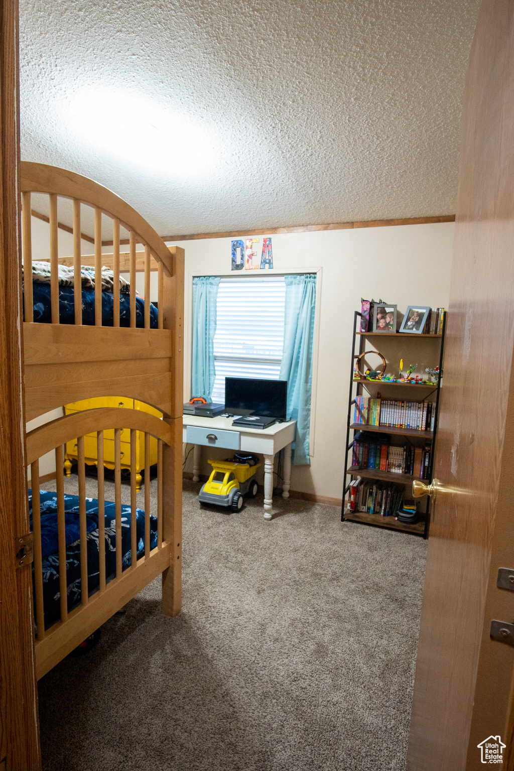 Carpeted bedroom with a textured ceiling