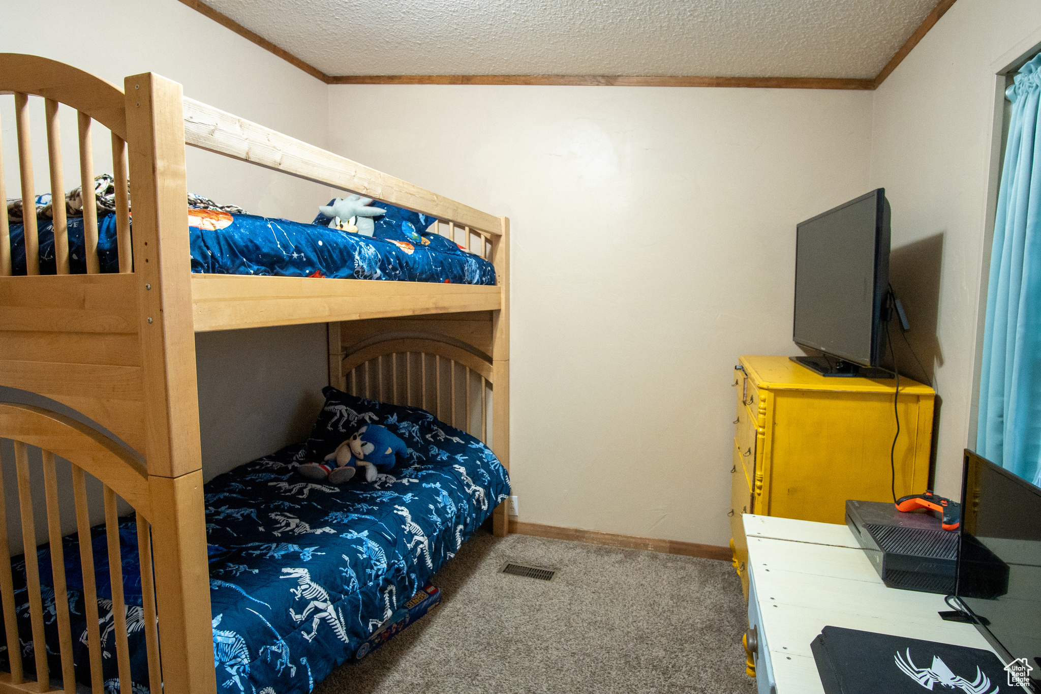 Bedroom featuring crown molding, carpet, and a textured ceiling