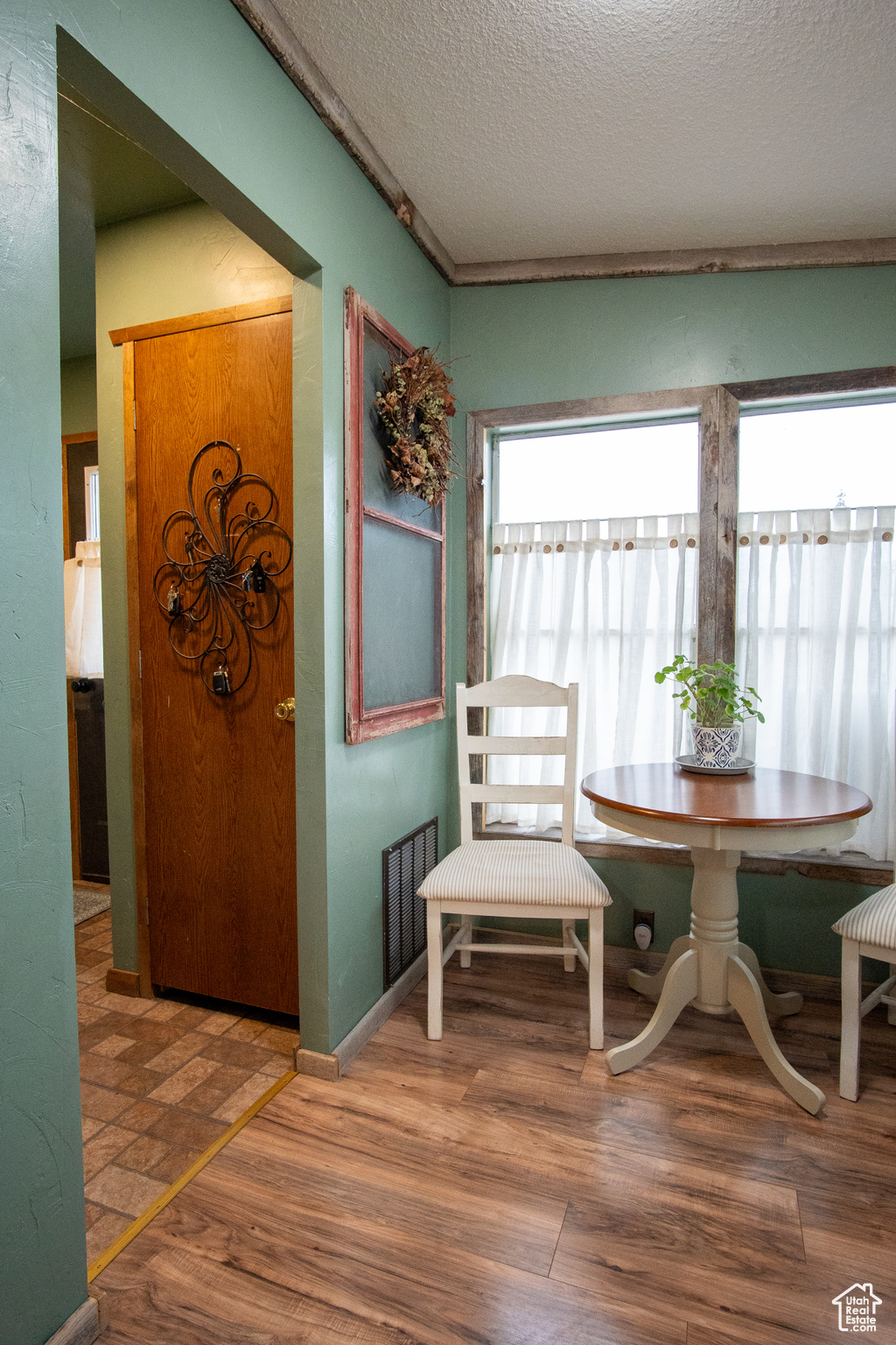 Dining room with breakfast area, a textured ceiling, and hardwood / wood-style flooring