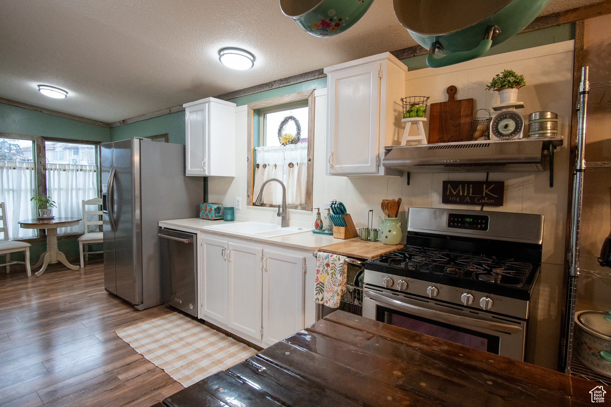 Kitchen with white cabinetry, appliances with stainless steel finishes, sink, and plenty of natural light