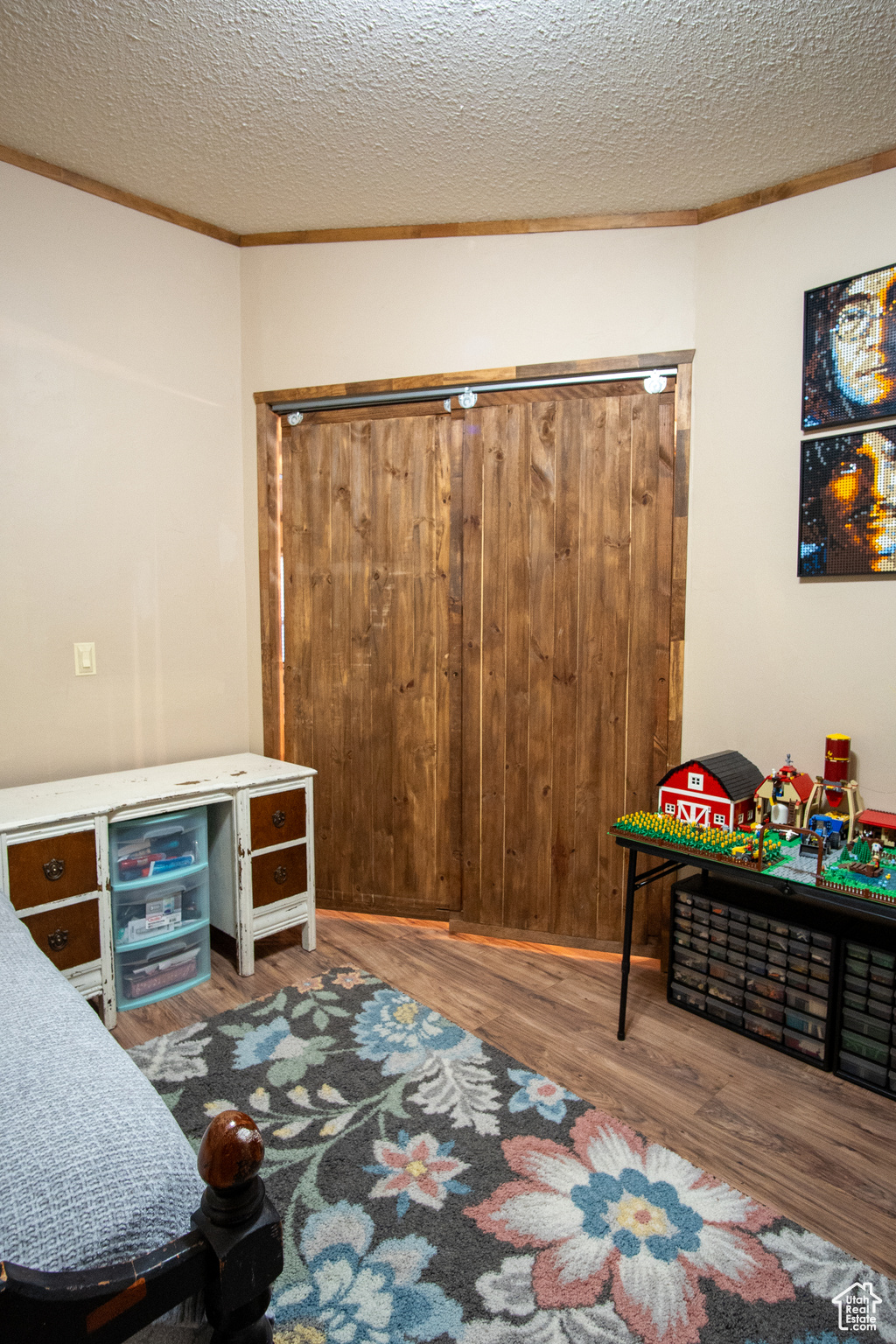 Interior space with ornamental molding, hardwood / wood-style floors, and a textured ceiling