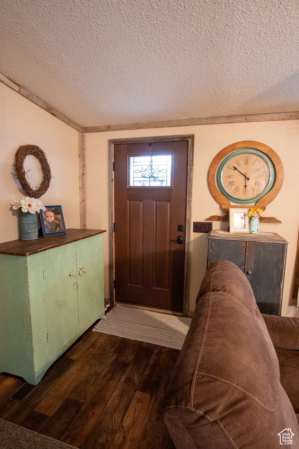 Entryway featuring crown molding, hardwood / wood-style floors, and a textured ceiling