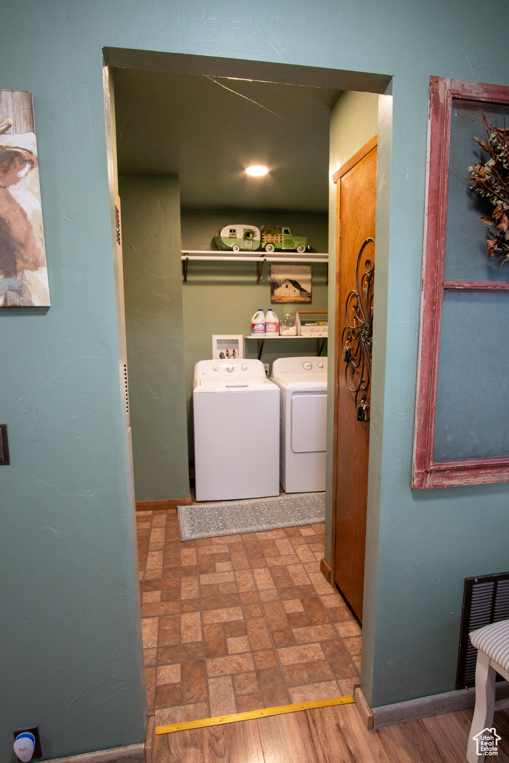 Laundry room with independent washer and dryer and wood-type flooring