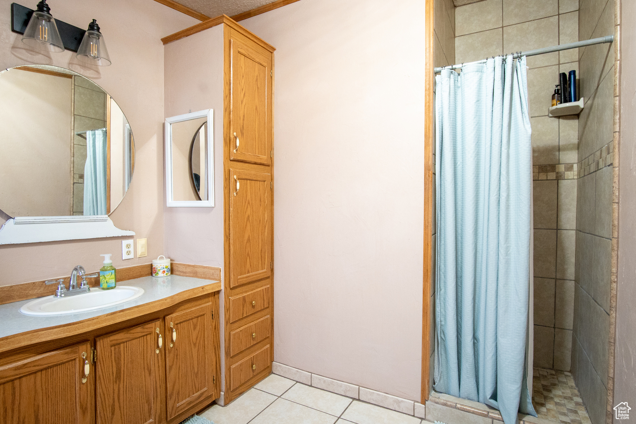 Bathroom featuring tile patterned flooring, vanity, and curtained shower