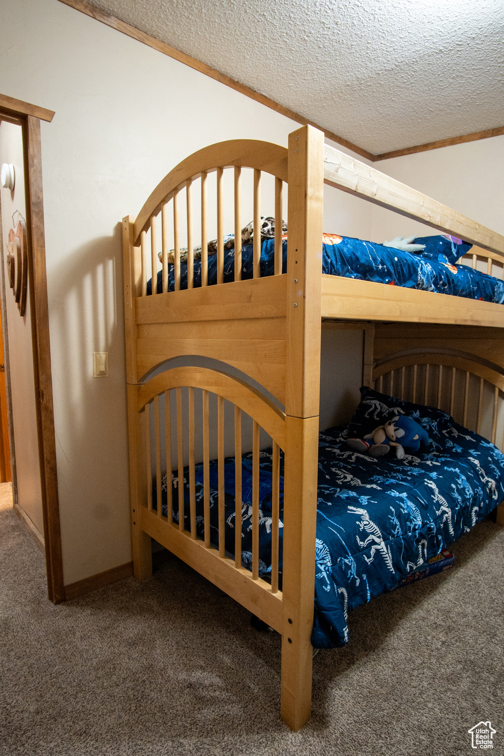 Bedroom with lofted ceiling, carpet, and a textured ceiling