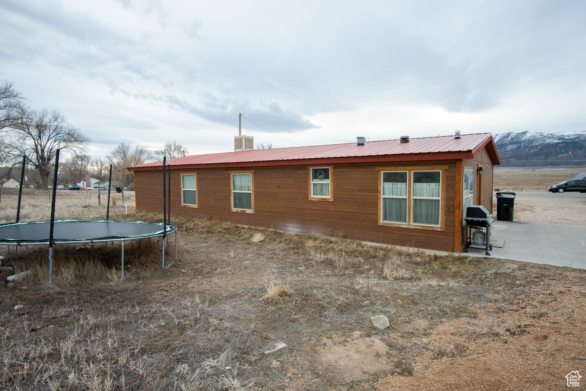 Rear view of property with a mountain view and a trampoline