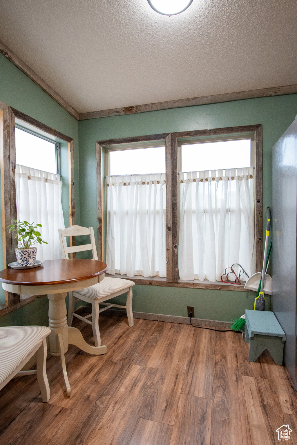 Dining space with hardwood / wood-style floors and a textured ceiling