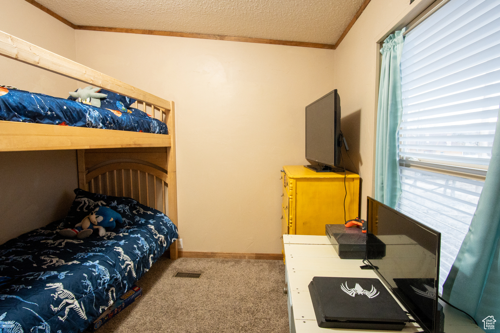 Bedroom with ornamental molding, carpet flooring, and a textured ceiling