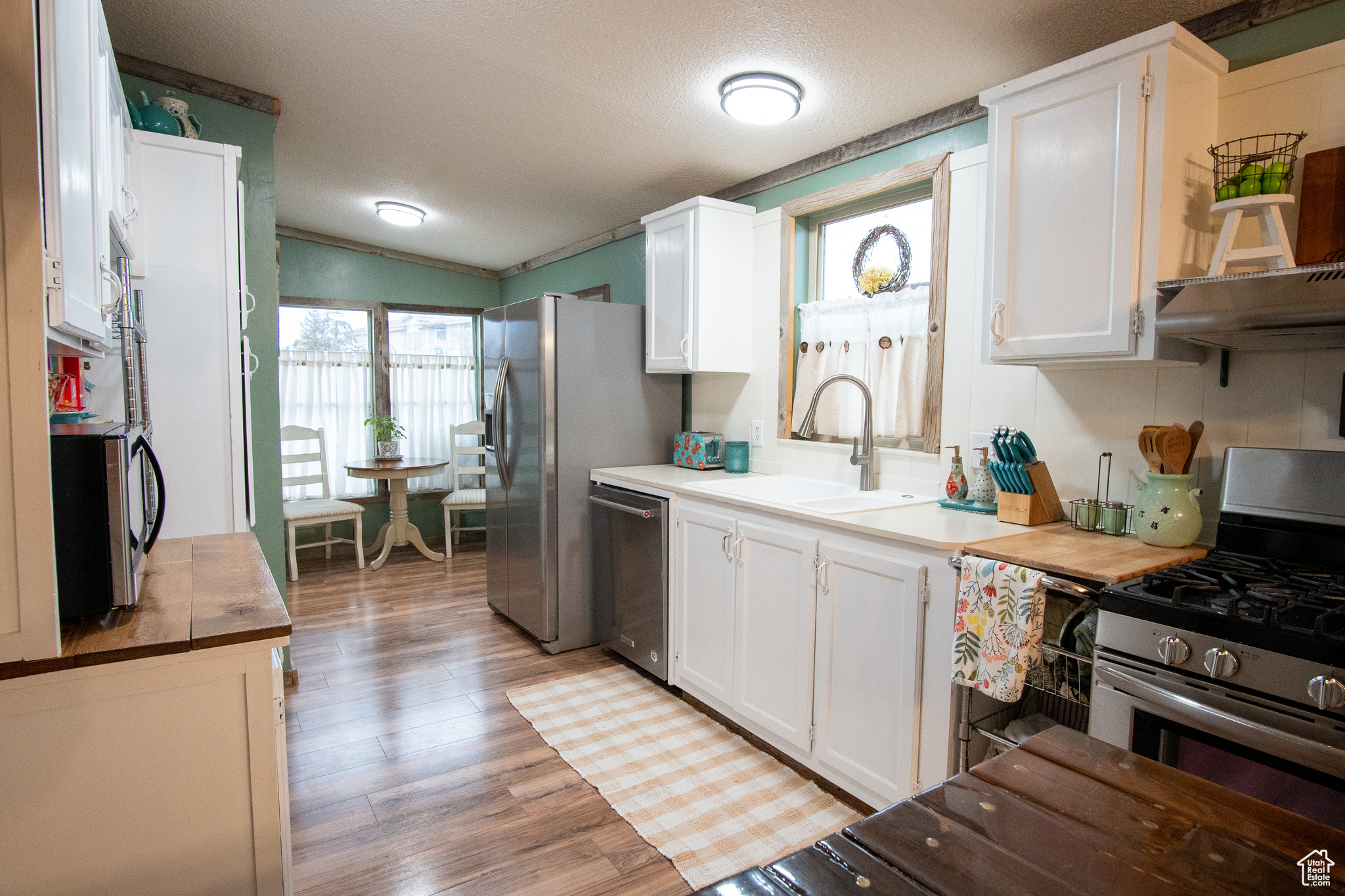 Kitchen with white cabinetry, stainless steel appliances, and sink