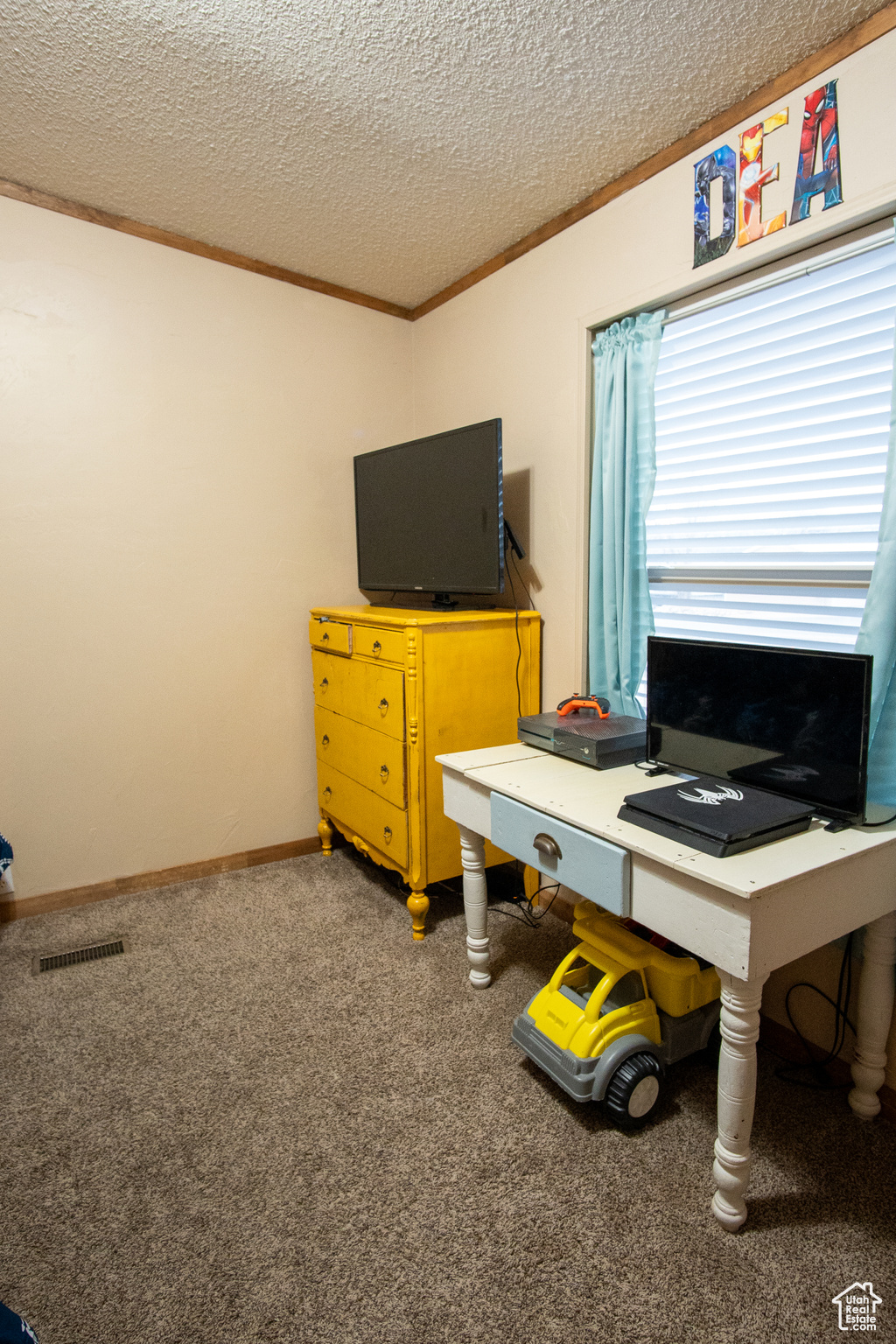 Carpeted home office featuring crown molding and a textured ceiling