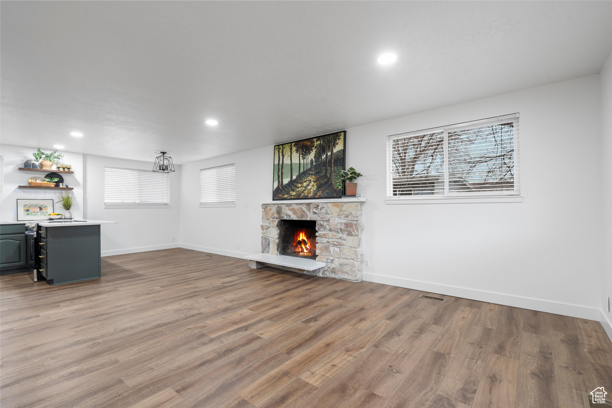 Unfurnished living room with hardwood / wood-style flooring and a stone fireplace