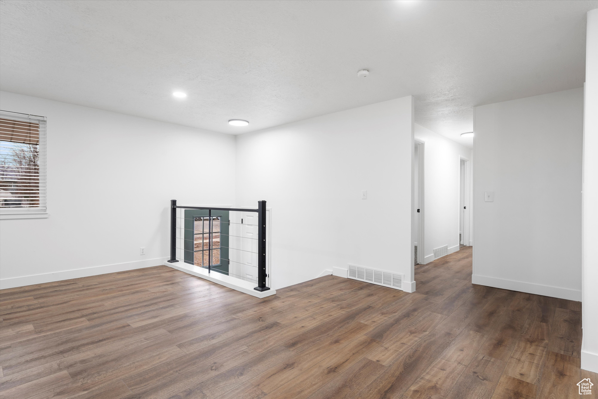 Empty room featuring dark hardwood / wood-style floors