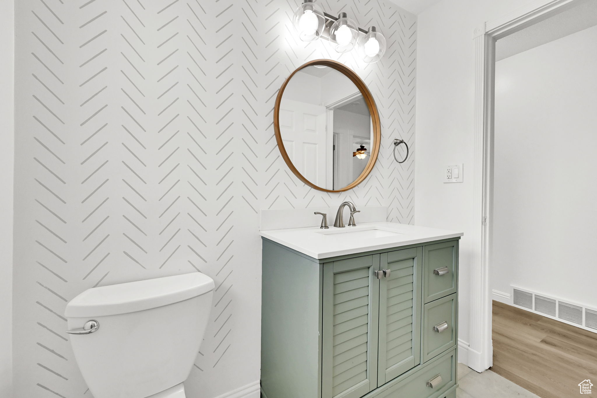 Bathroom with hardwood / wood-style flooring, vanity, and toilet