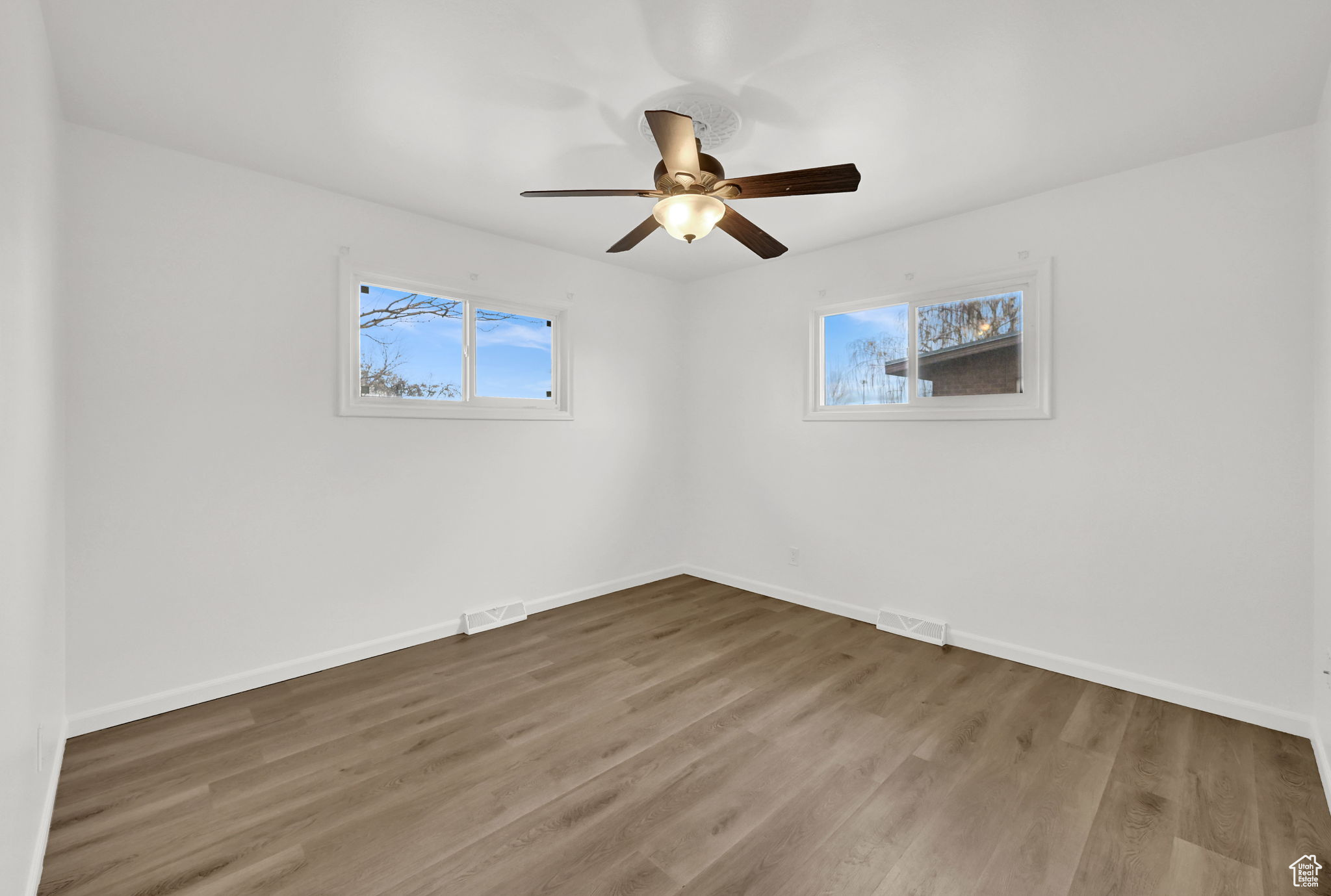 Empty room featuring wood-type flooring and ceiling fan