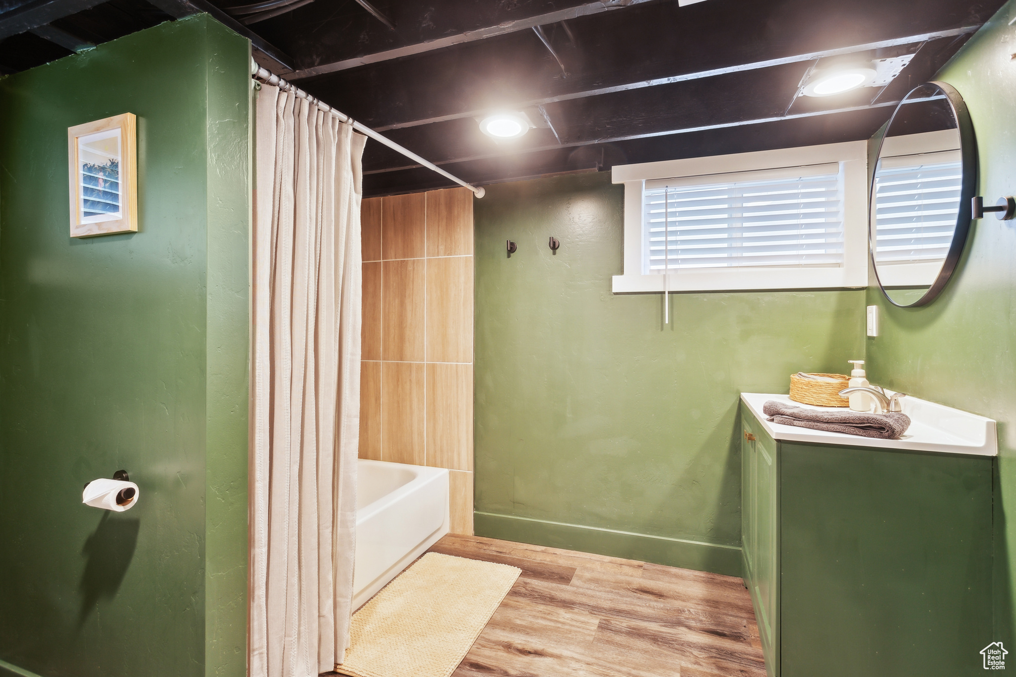 Bathroom with vanity, wood-type flooring, and shower / bath combination with curtain